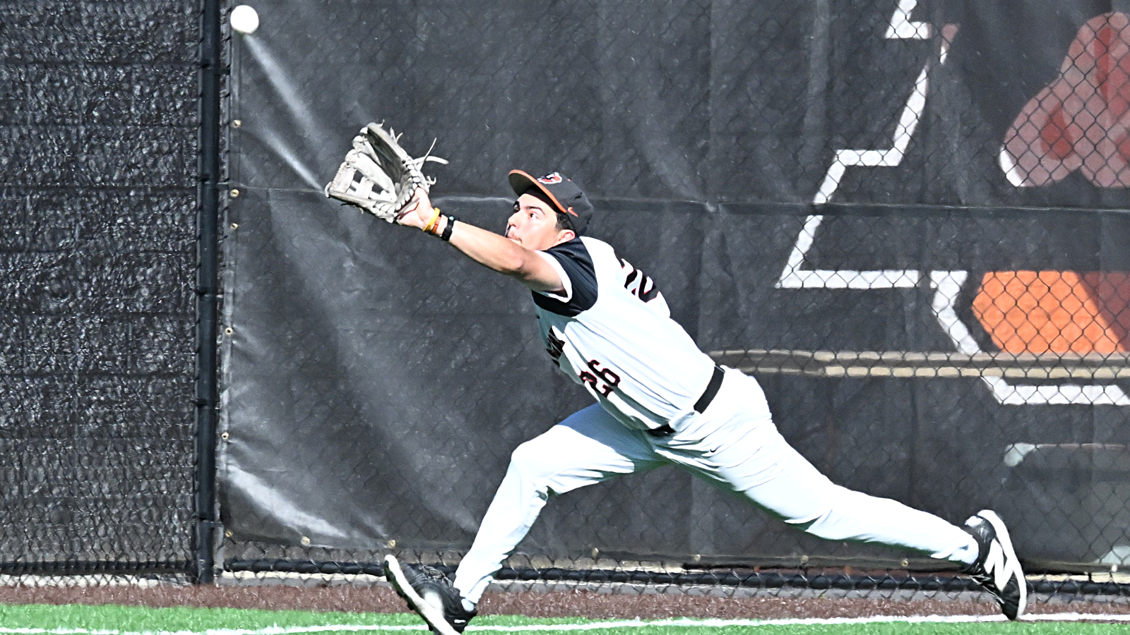 Will Michelman reaches for the baseball to record an out in left field. 