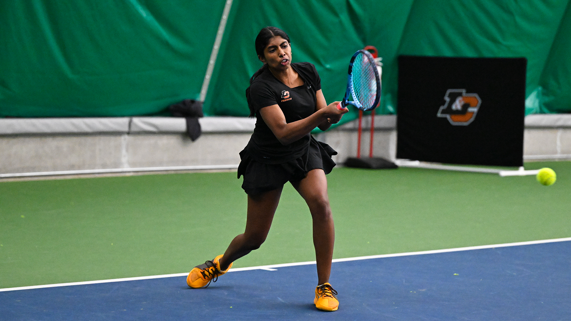 Susanna Anand hits a baseline backhand