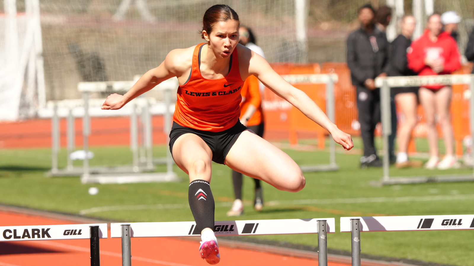 Elsie Chin jumps over a hurdle 