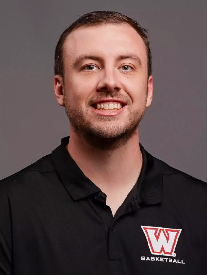 Alex Saindon smiles in front of grey background