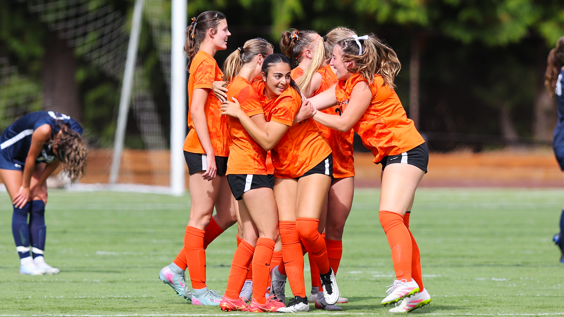 Women's soccer players celebrate after a win. 