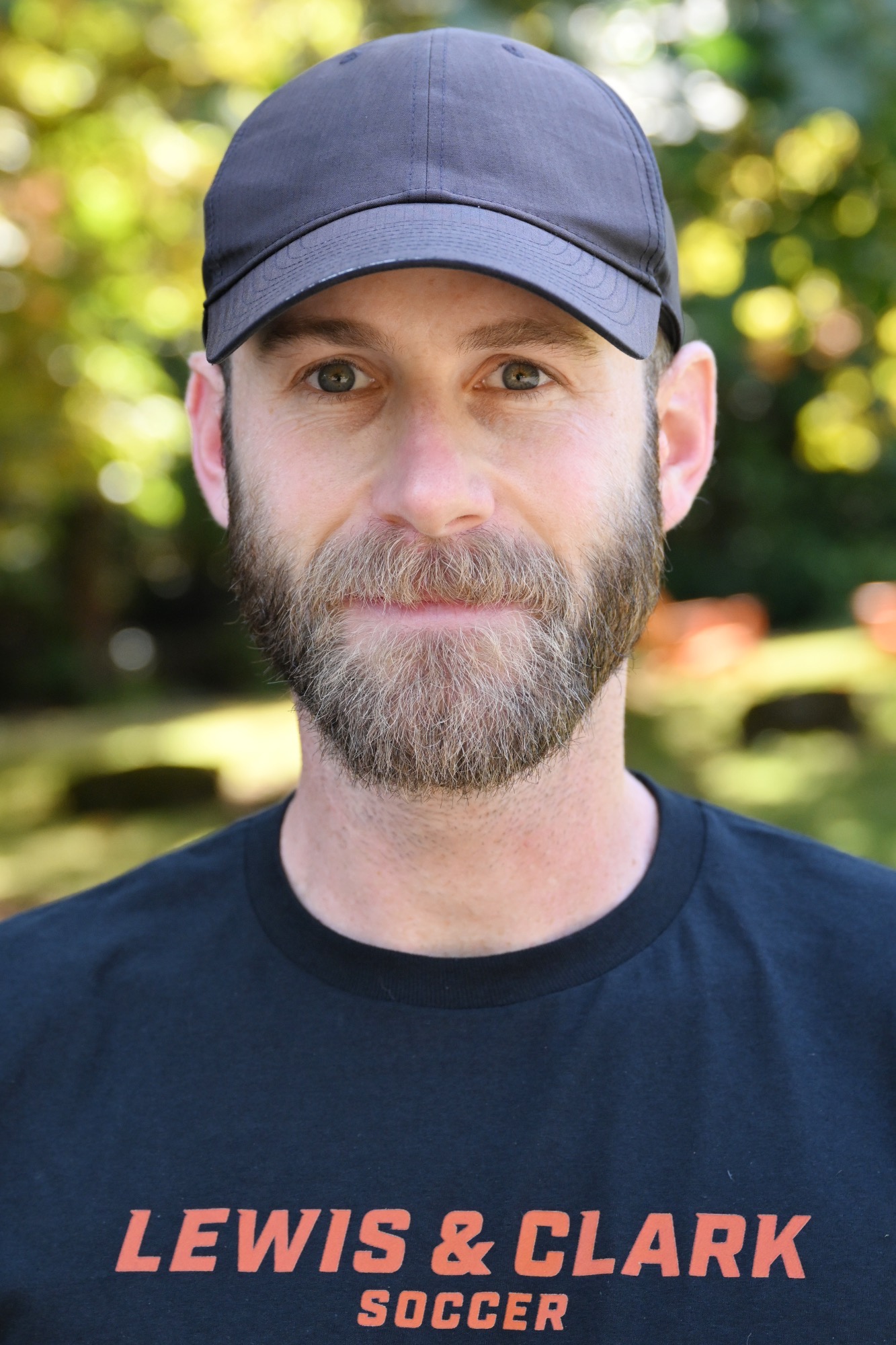 Daniel Gradison smiles in front of a green backdrop 