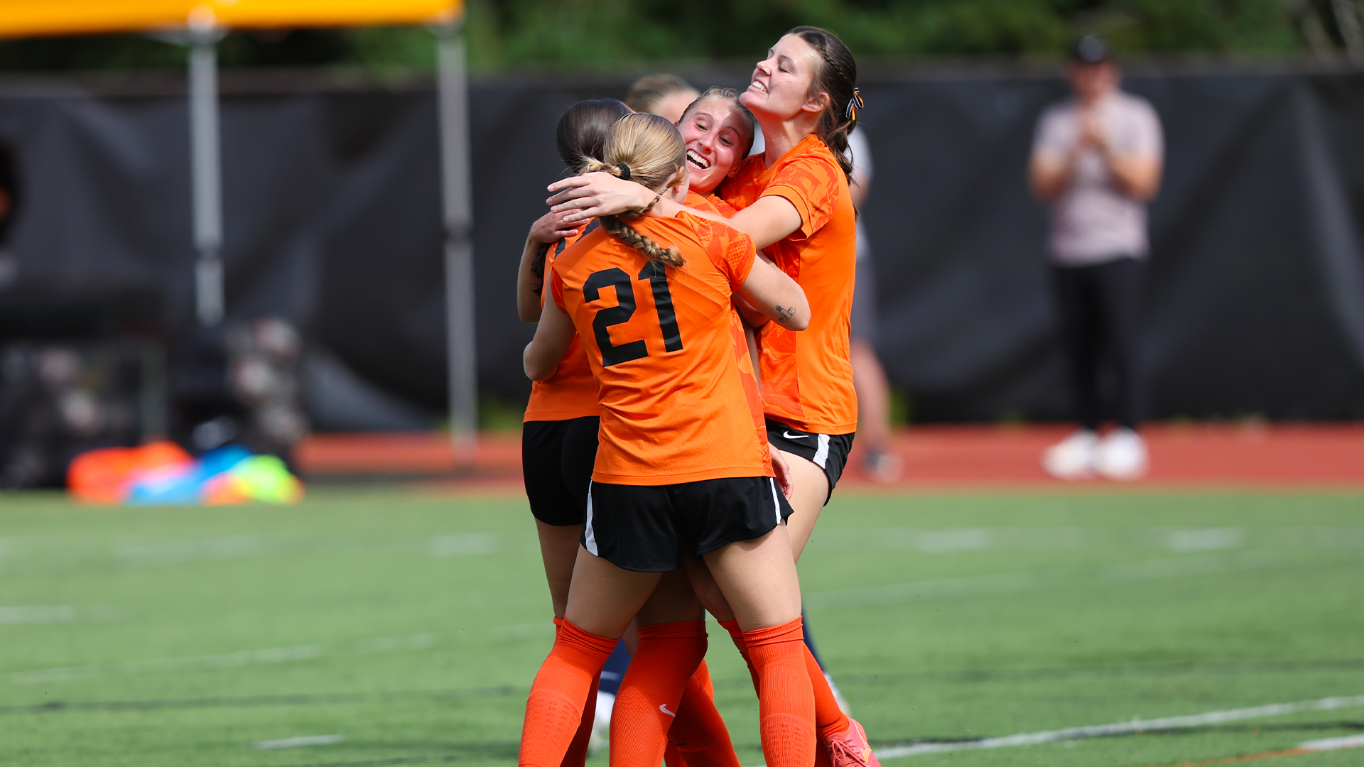 Women's soccer players celebrate after a goal. 
