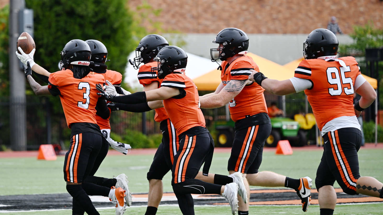 Football defense celebrates recording an interception against Puget Sound