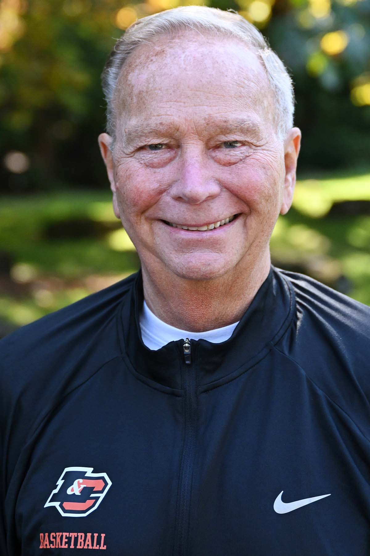 Mark Swenson smiles in front of a green background. 