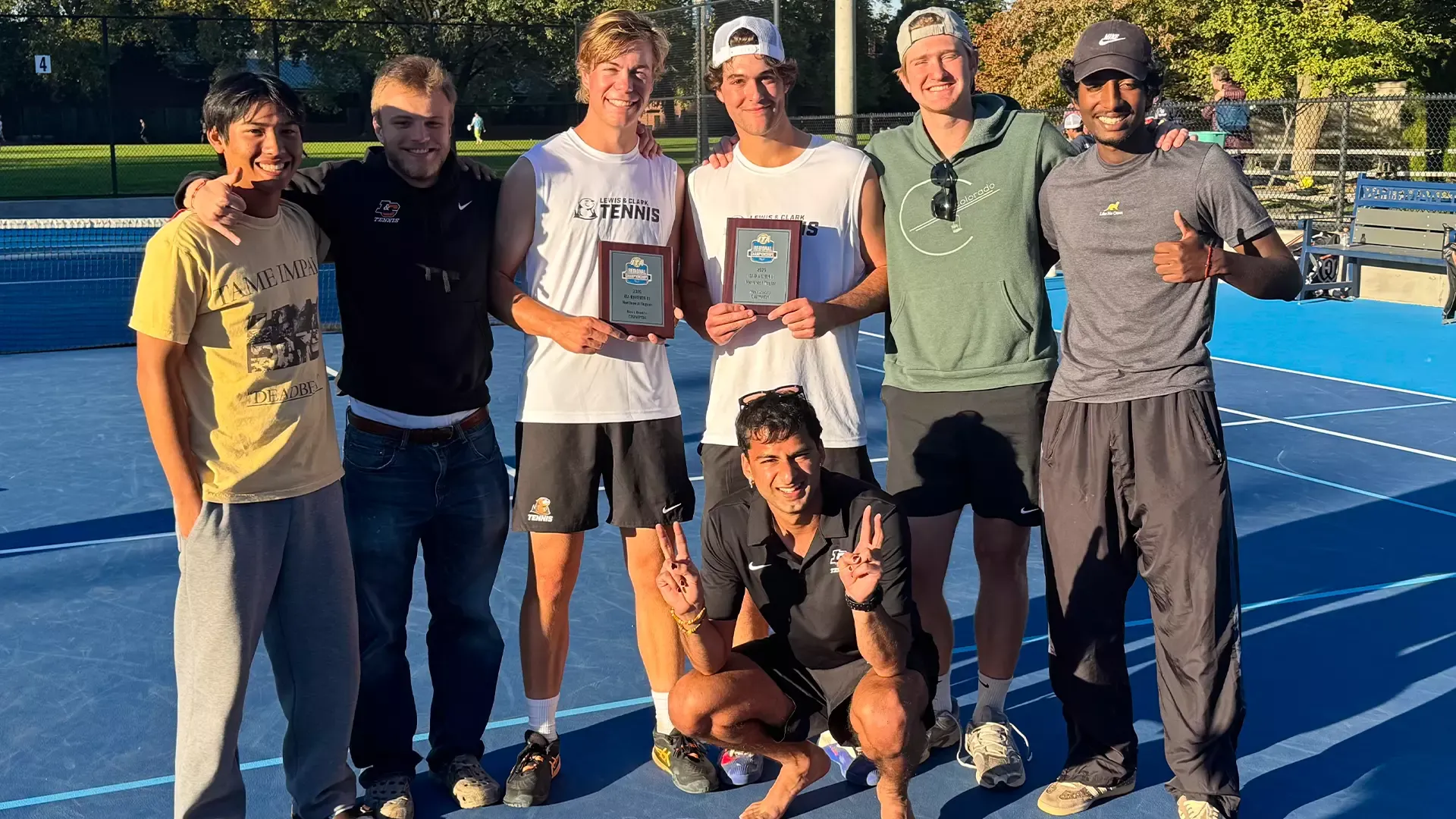 Quinn Douangpanya, Aslan Gemuhluoglu, Kaden Sigurdsson, Noah Sutin, Bridger Galyardt, Ethan Annand and Arnav Bishnoi smile on a tennis court. 