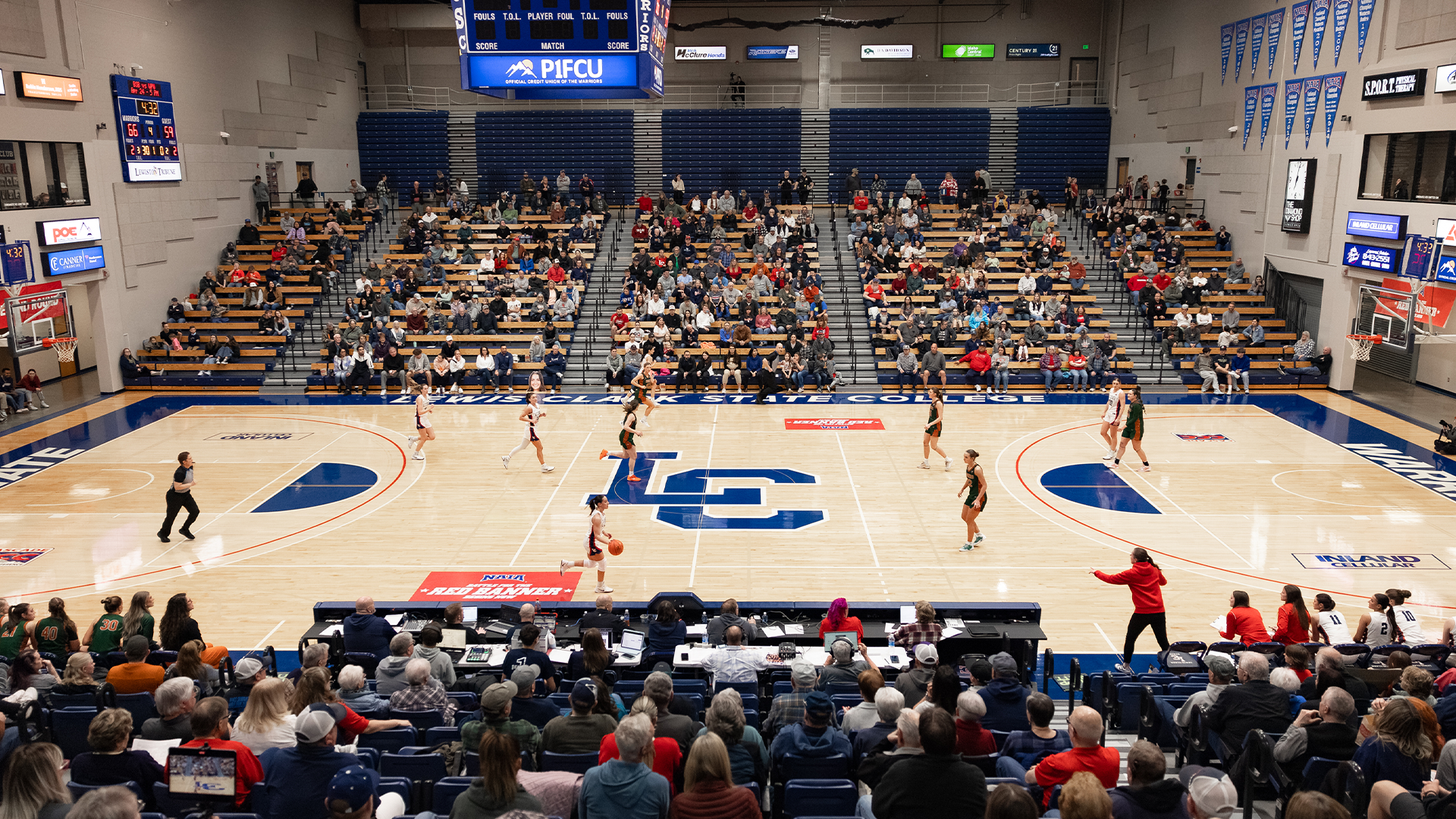 Women's basketball playing a game in the P1FCU Activity Center