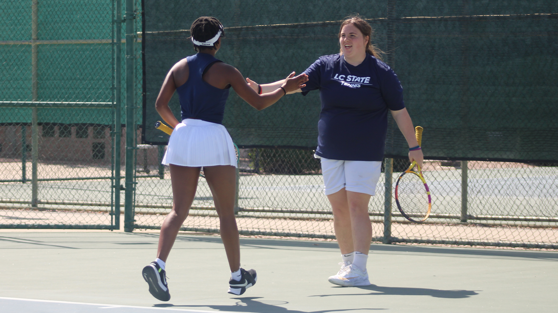 Rylie Gettmann and Lulu Monnayoo high five on the court