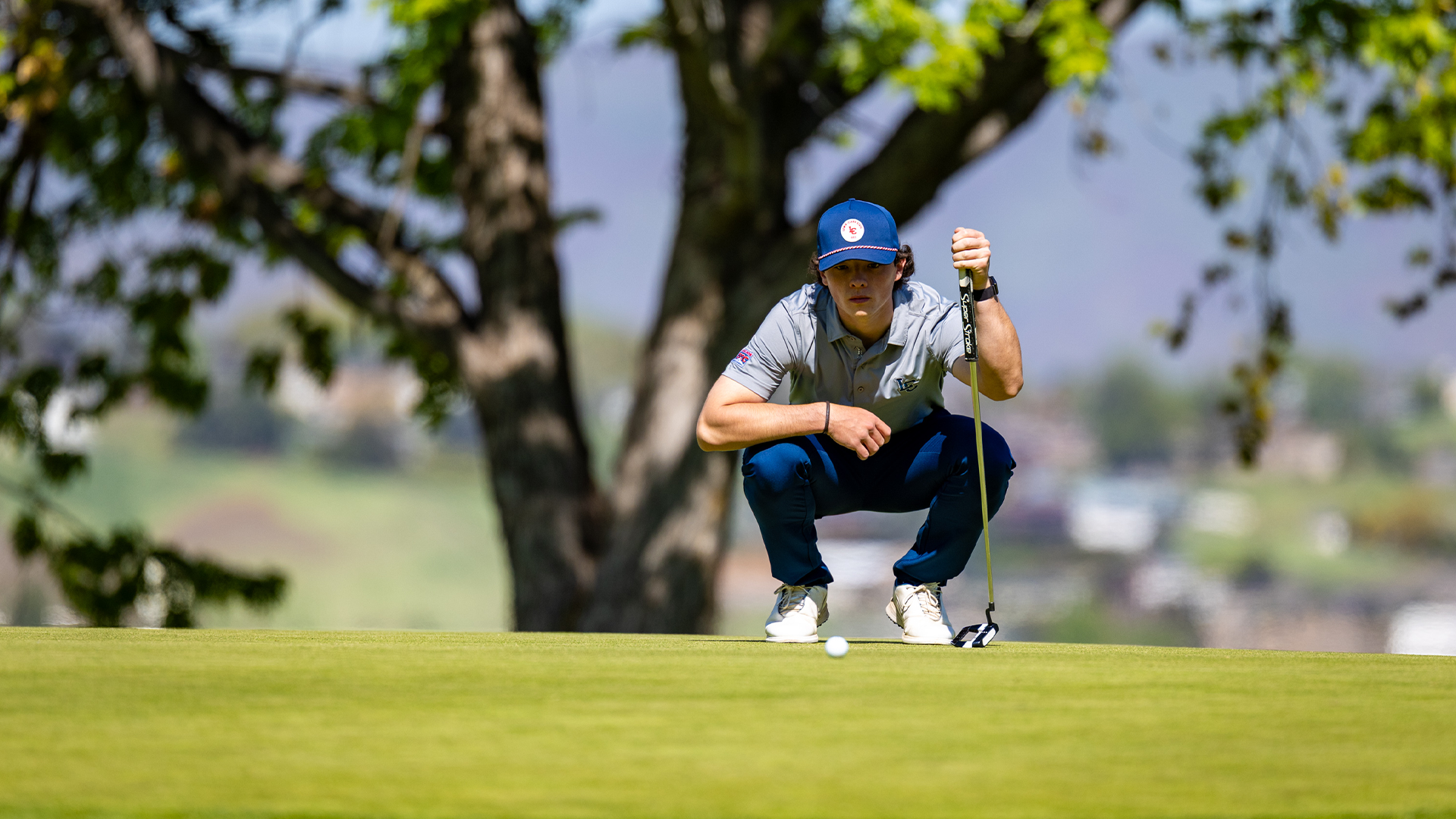 Adam Lovatt squats down to look at a putt