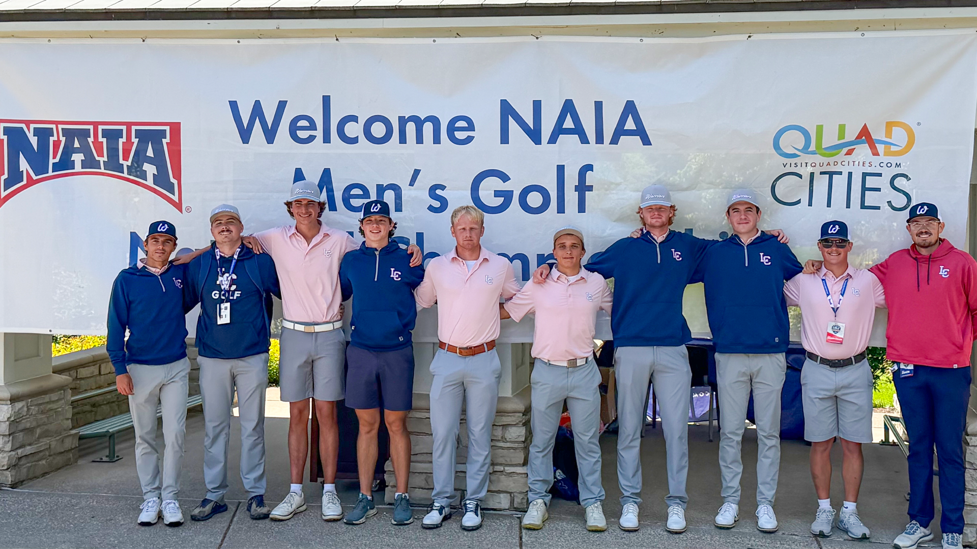 Men's golf team poses in front of NAIA banner