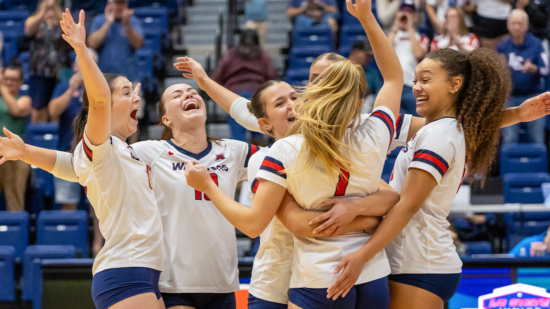 Members of the volleyball team celebrate on the court
