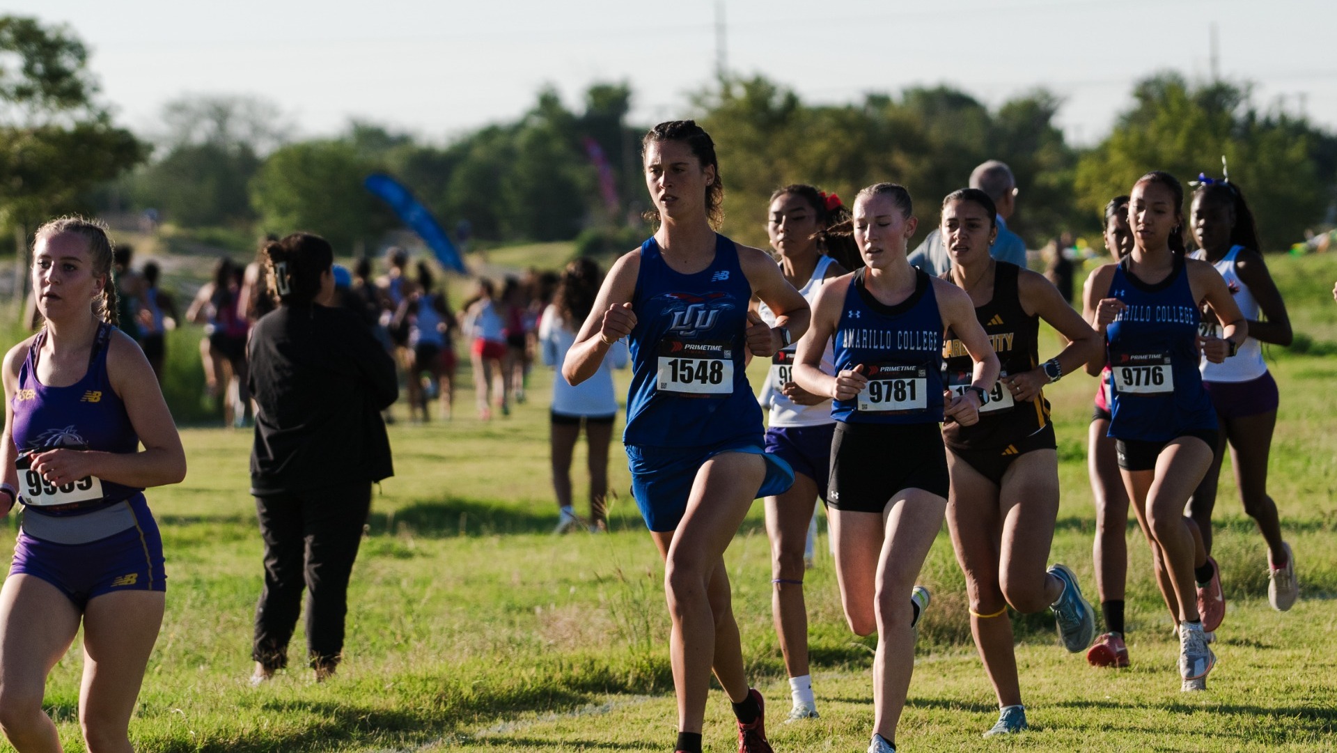 This is a photo of a group of women running at a cross country race. 