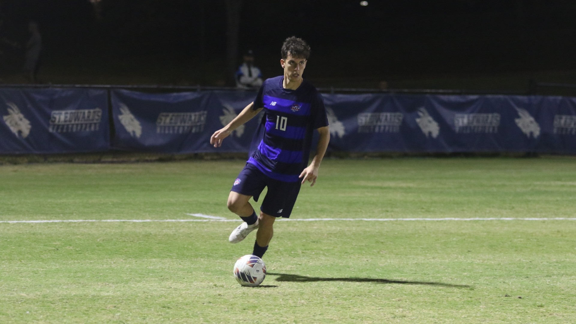 This is a photo of Manu Nunez (#10) dribbling the soccer ball during a game at Lewis Chen Family Field in Austin, Texas. 