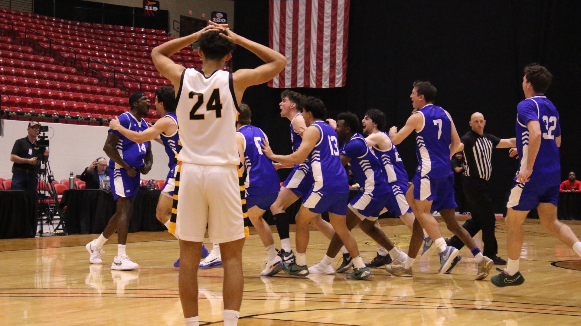 This is a photo of members of the Lubbock Christian men's basketball team (blue jerseys) celebrating after a buzzer-beater win against West Liberty (white jersey) at the South Point Arena.