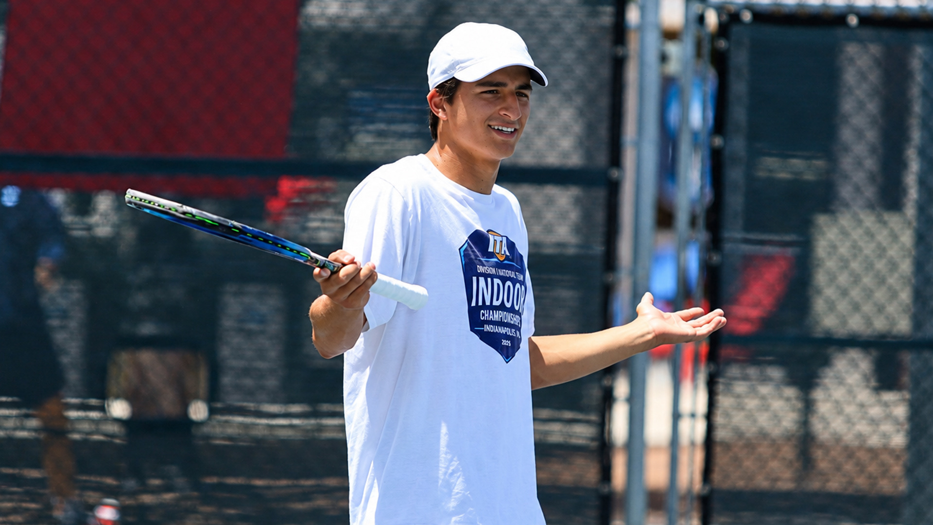 Photo of a male tennis player in a white cap and a white 