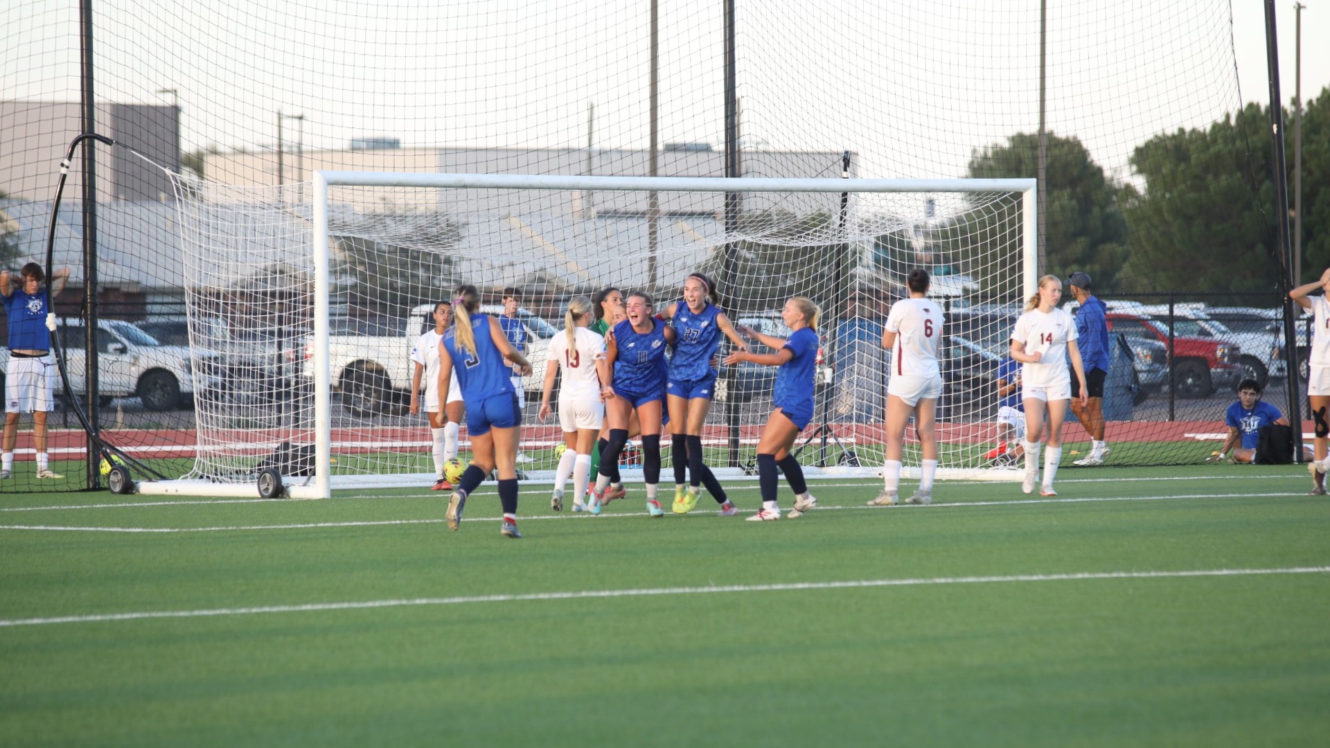 This is a photo of Lubbock Christian women's soccer players Kali Guy (left, blue jersey, #11) and Claire Jacobson (right, blue jersey, #27) celebrating after a Lady Chap goal scored.