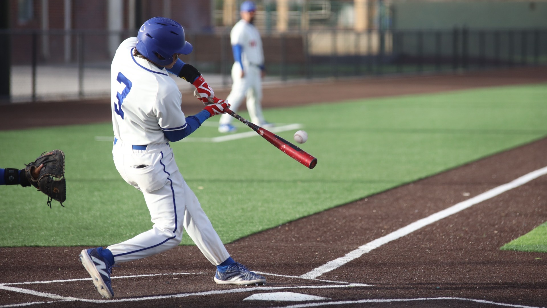 This is a photo of Lubbock Christian infielder Joe Mancinas (white jersey, #3) hitting a baseball during a game at Hays Field.