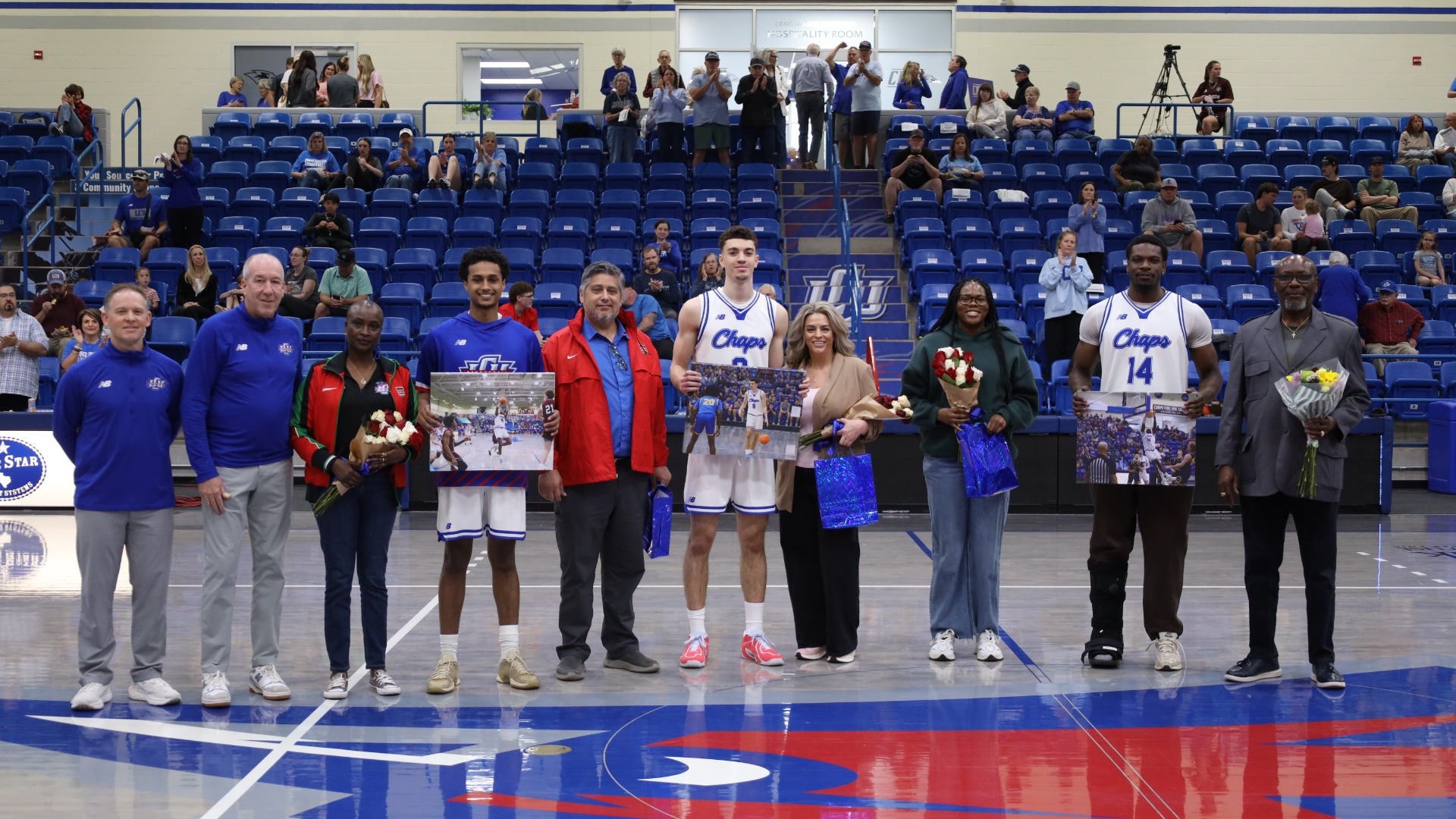 This is a photo of the three Lubbock Christian men's basketball seniors, their families and the team's coaches prior to a game.