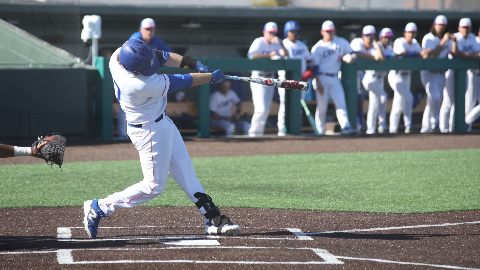 This is a photo of Lubbock Christian designated hitter Owen Alsup (white jersey, #17) hitting a ball during a game at Hays Field. 