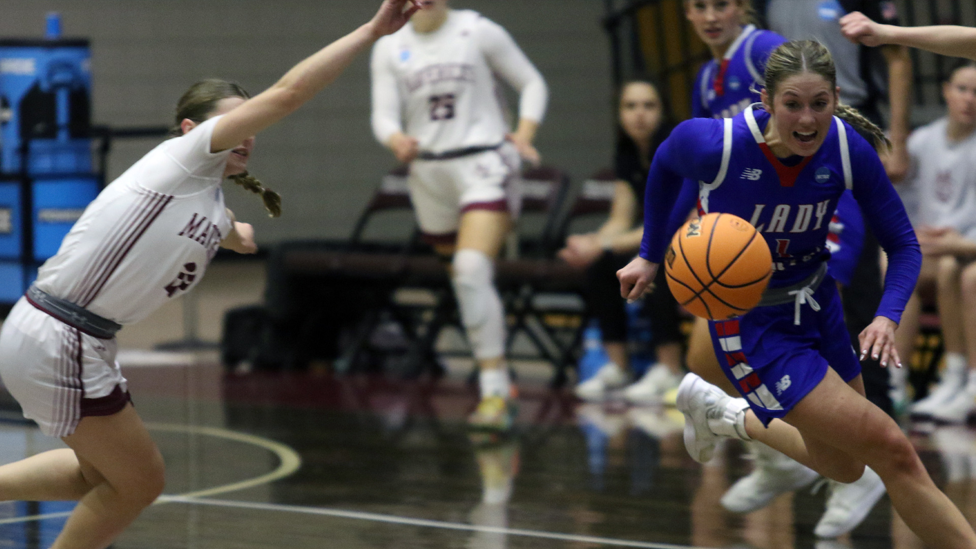An LCU Lady Chaps player in a blue Lady Chaps uniform drives past a Colorado Mesa defender during the NCAA DII South Central Regional game at Kitty Magee Arena in Denton, Texas