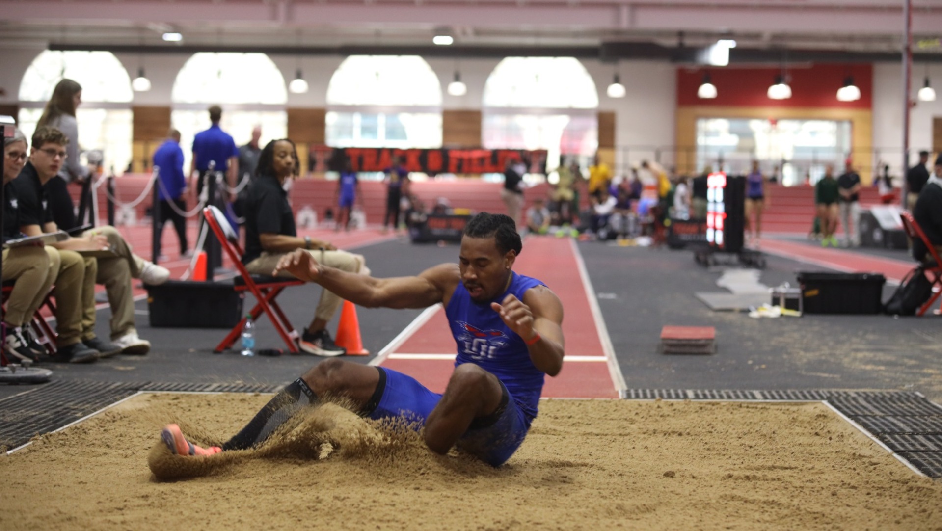 This is a photograph of Lubbock Christian field athlete Maurice Gray landing in the long jump pit. 