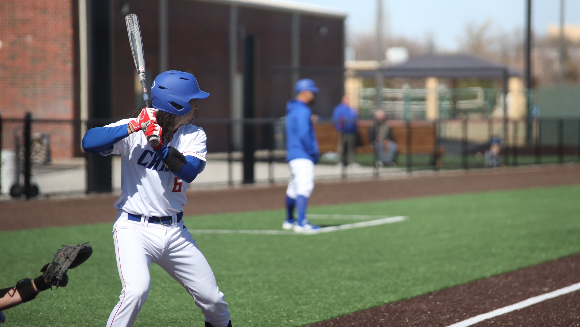 This is a photo of Lubbock Christian's Jorge De Los Santos (white jersey, #6) preparing to swing at a pitch during a game at Hays Field. 