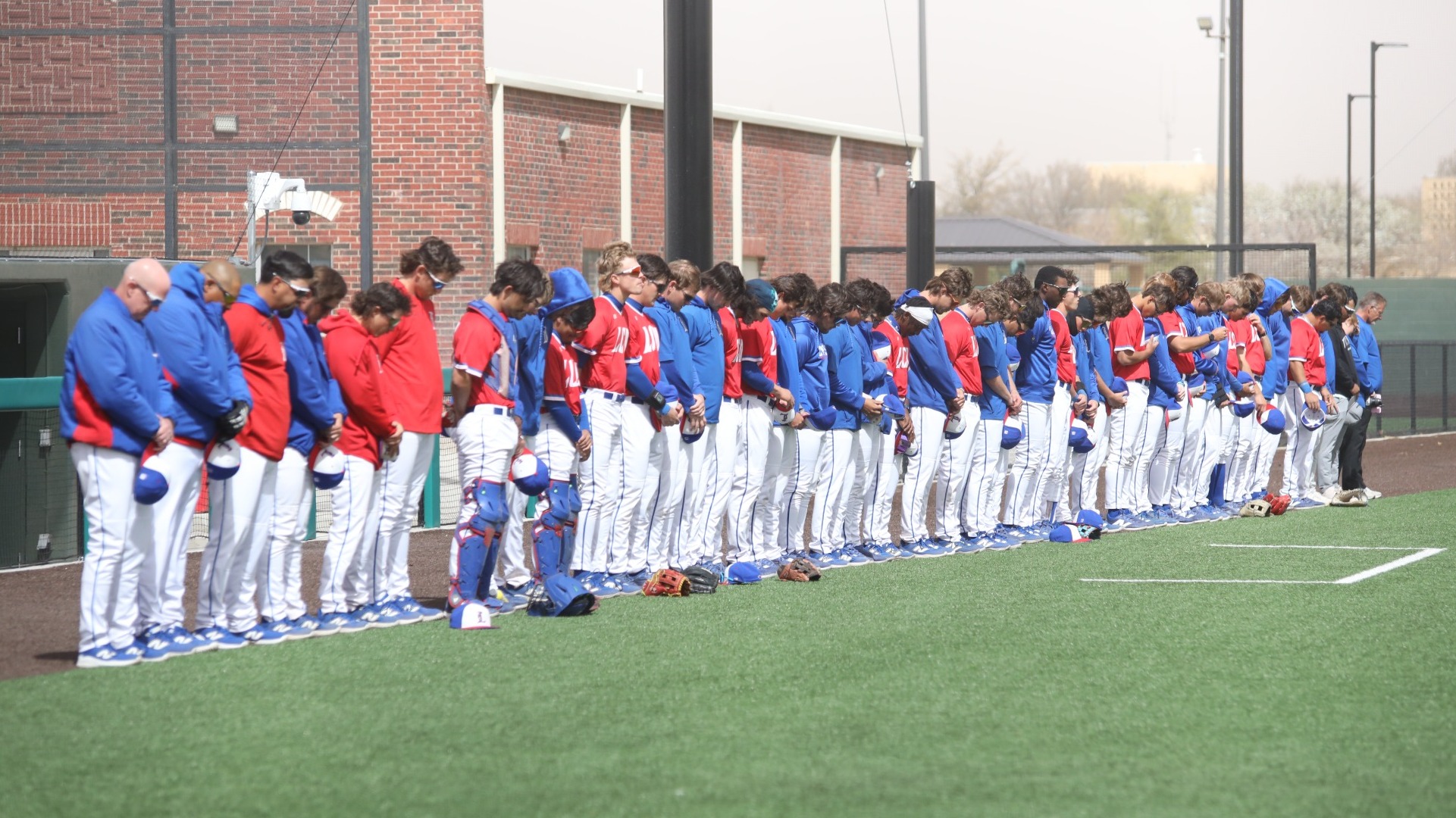 This is a photo of the Lubbock Christian baseball team standing in prayer prior to a game at Hays Field. 