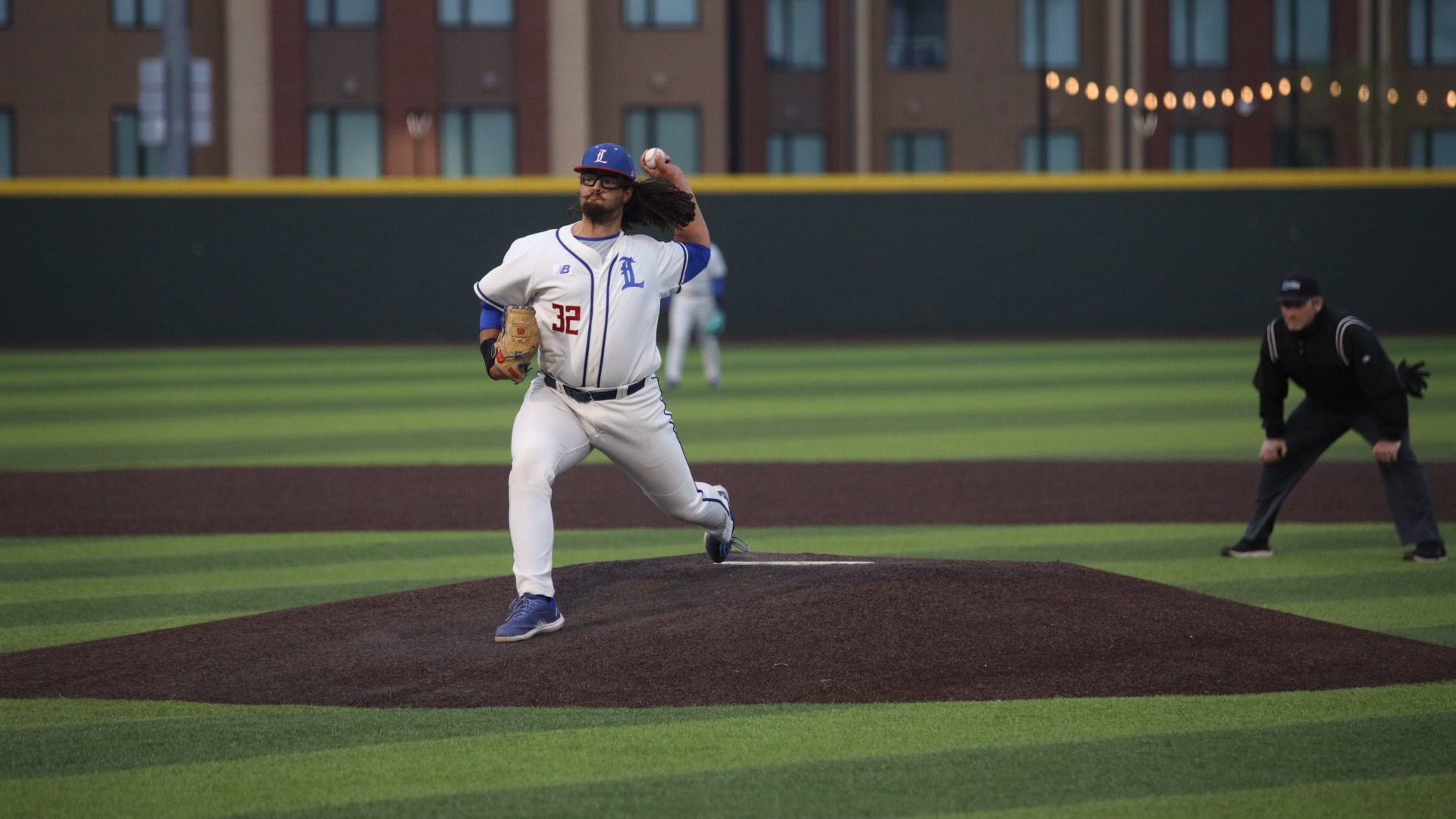 This is a photo of Lubbock Christian pitcher Kyle England (white jersey, #32) throwing a pitch during a game at Hays Field. 