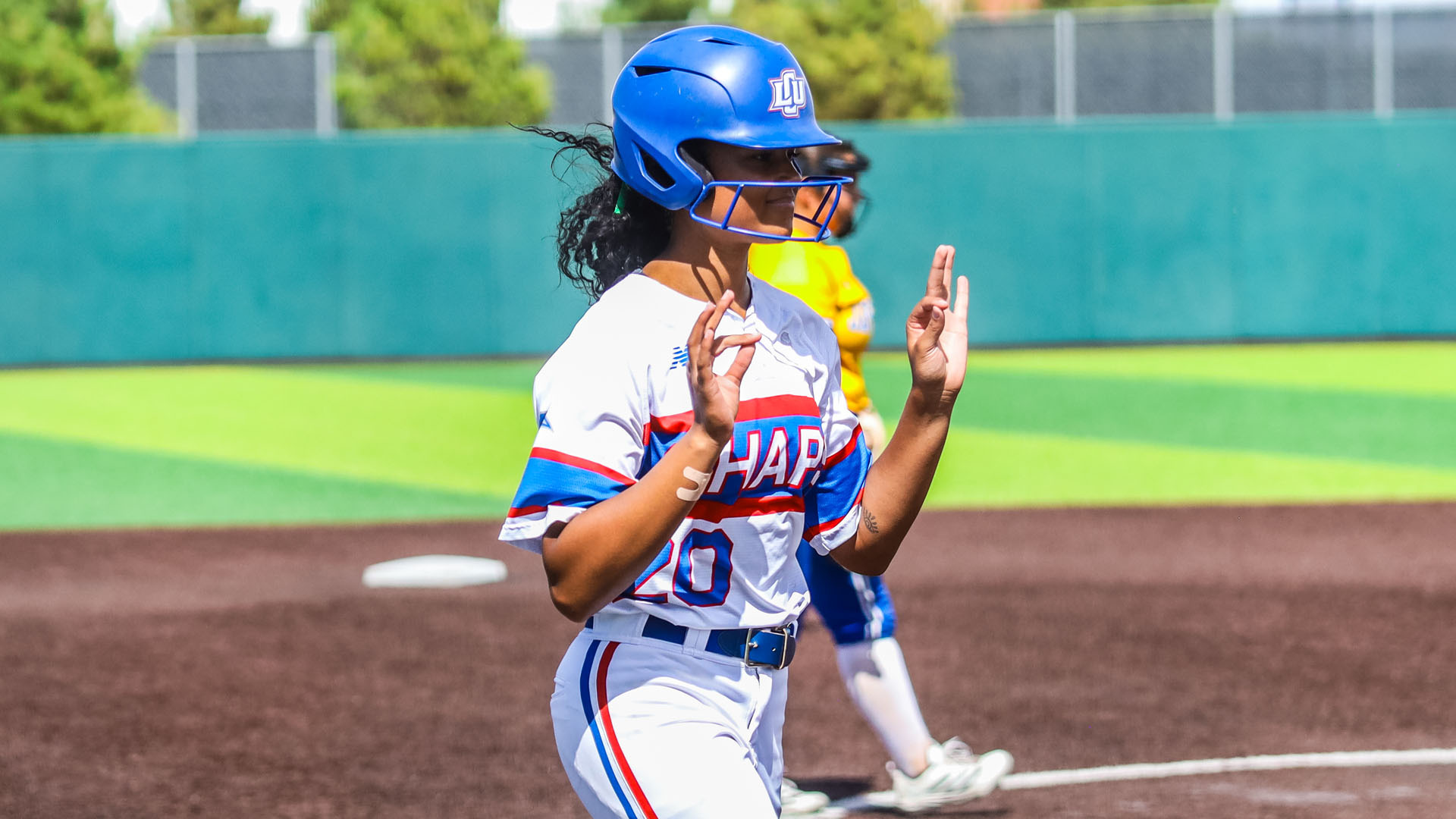 A Lady Chaps softball player (#20) in a white 