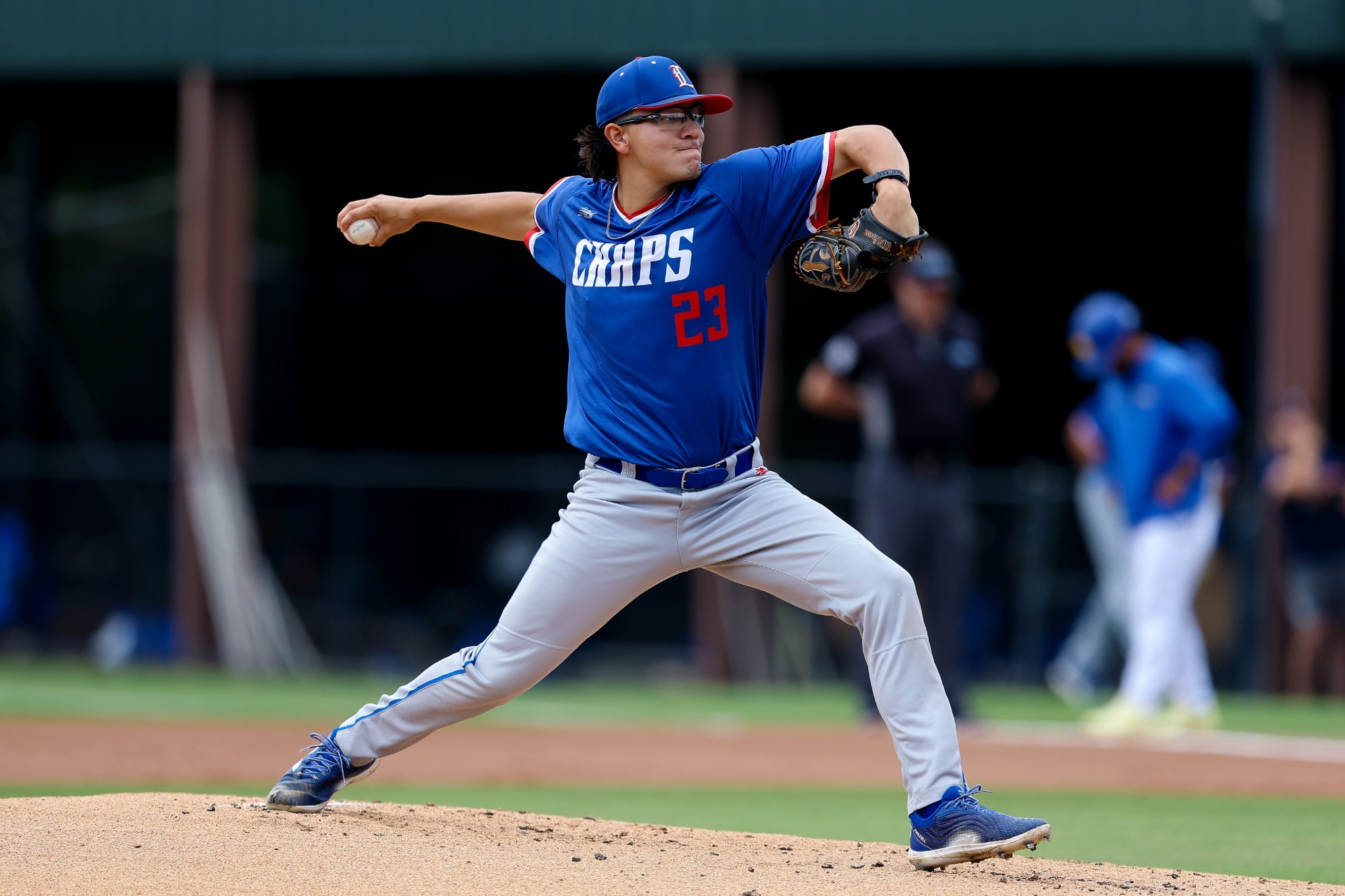 This is a photo of Lubbock Christian pitcher Aaron Rubio (blue jersey, #23) throwing a pitch during a game at Irwin Field 