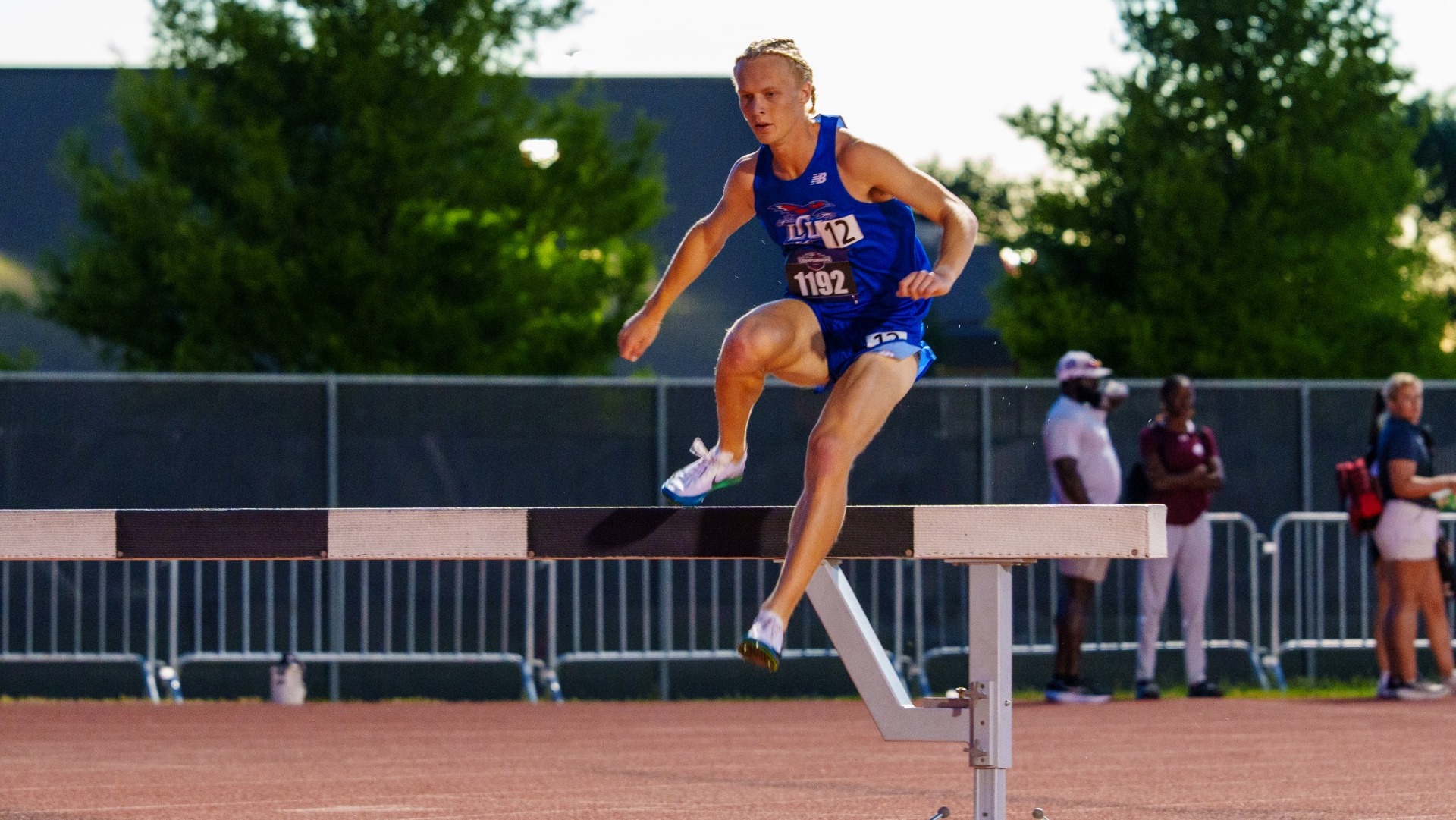 This is a photo of Lubbock Christian athlete Alfons Rawall clearing the hurdle during the steeplechase at the LSC Outdoor Championships.