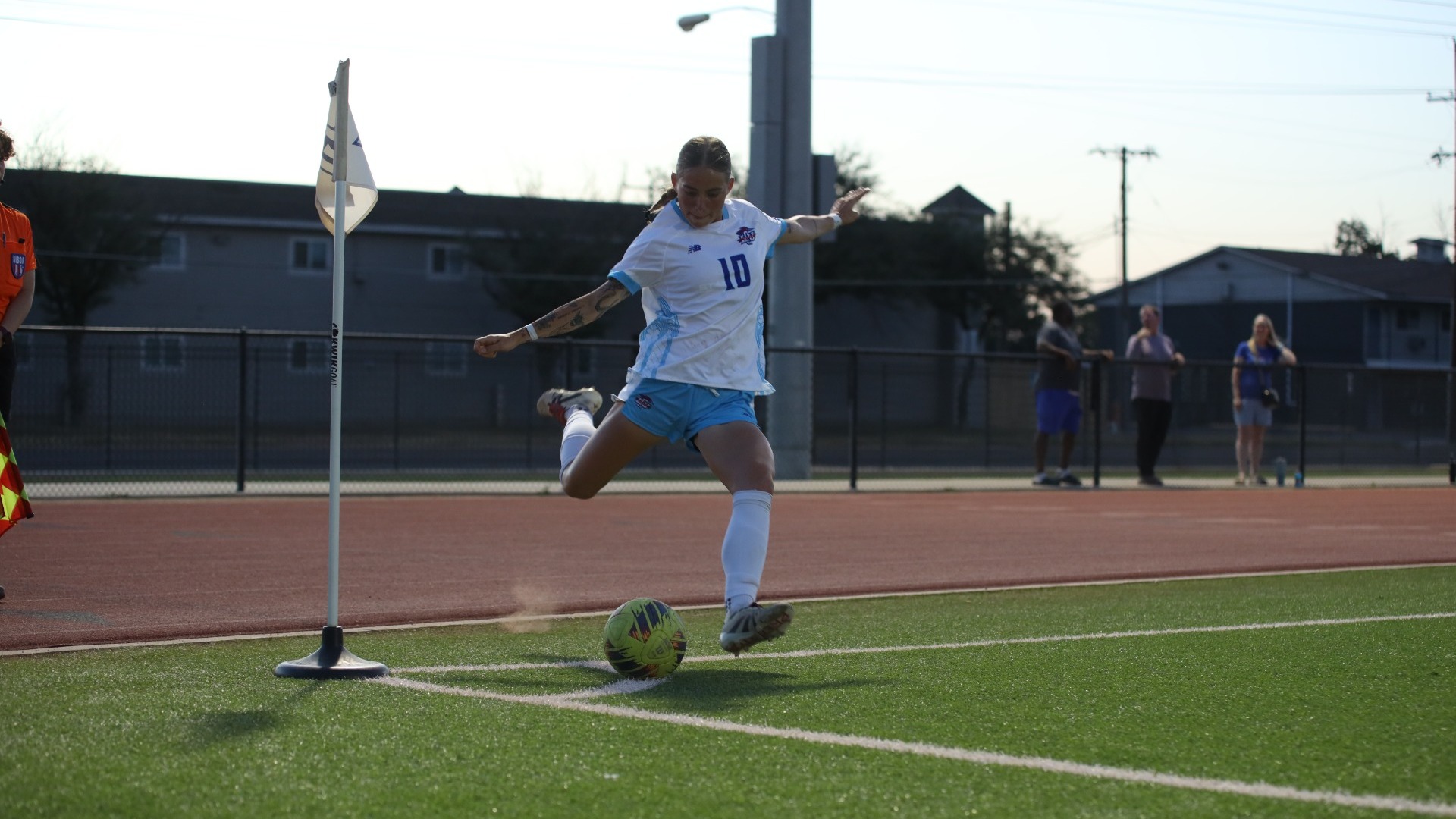 Lubbock Christian women's soccer player Journey Curs (white jersey, #10) takes a corner kick during a game at the LCU Soccer & Track Complex.