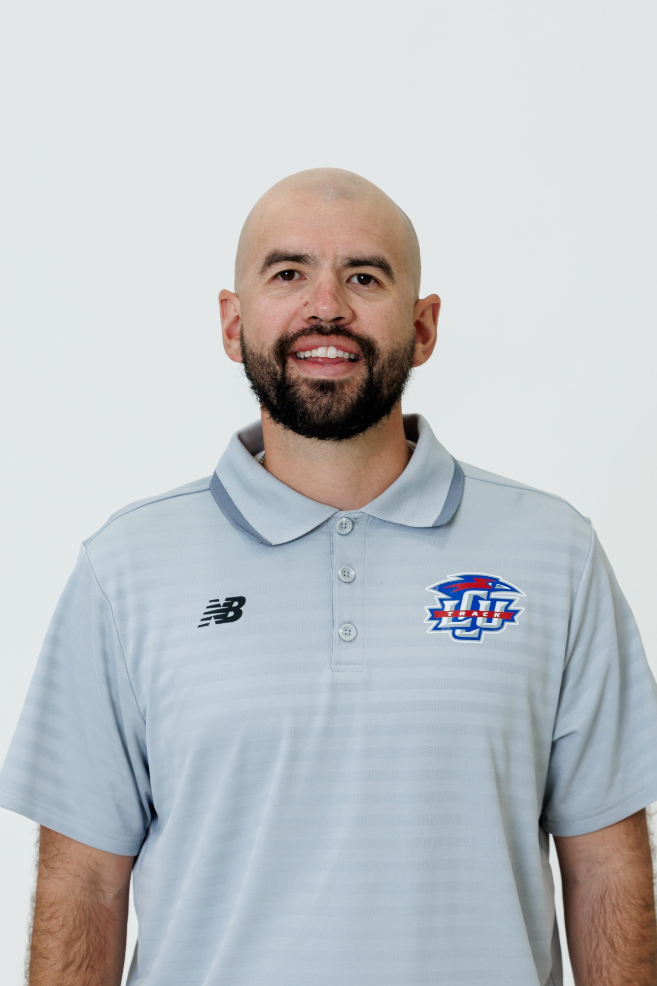 Headshot of Nicholas Rivera wearing a grey polo with the LCU logo on the right hand portion of the chest. 