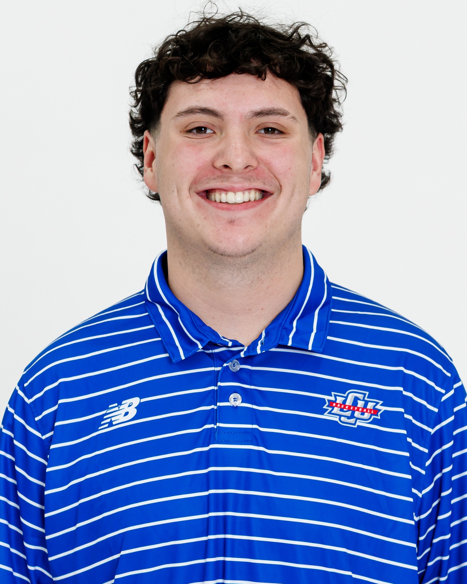 A Lubbock Christian men's basketball player wearing a blue polo with white stripes.