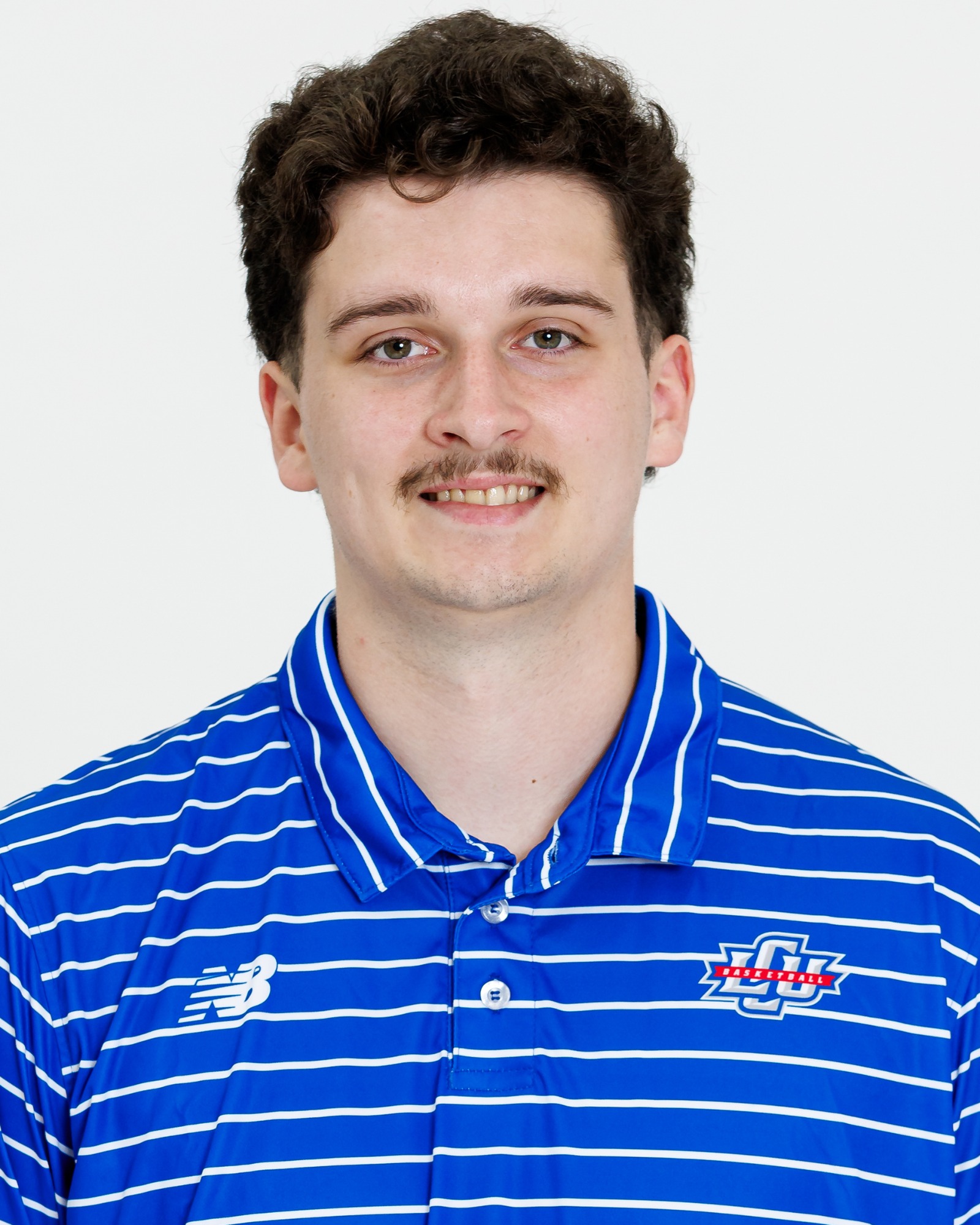 A Lubbock Christian men's basketball player wearing a blue polo with white stripes.