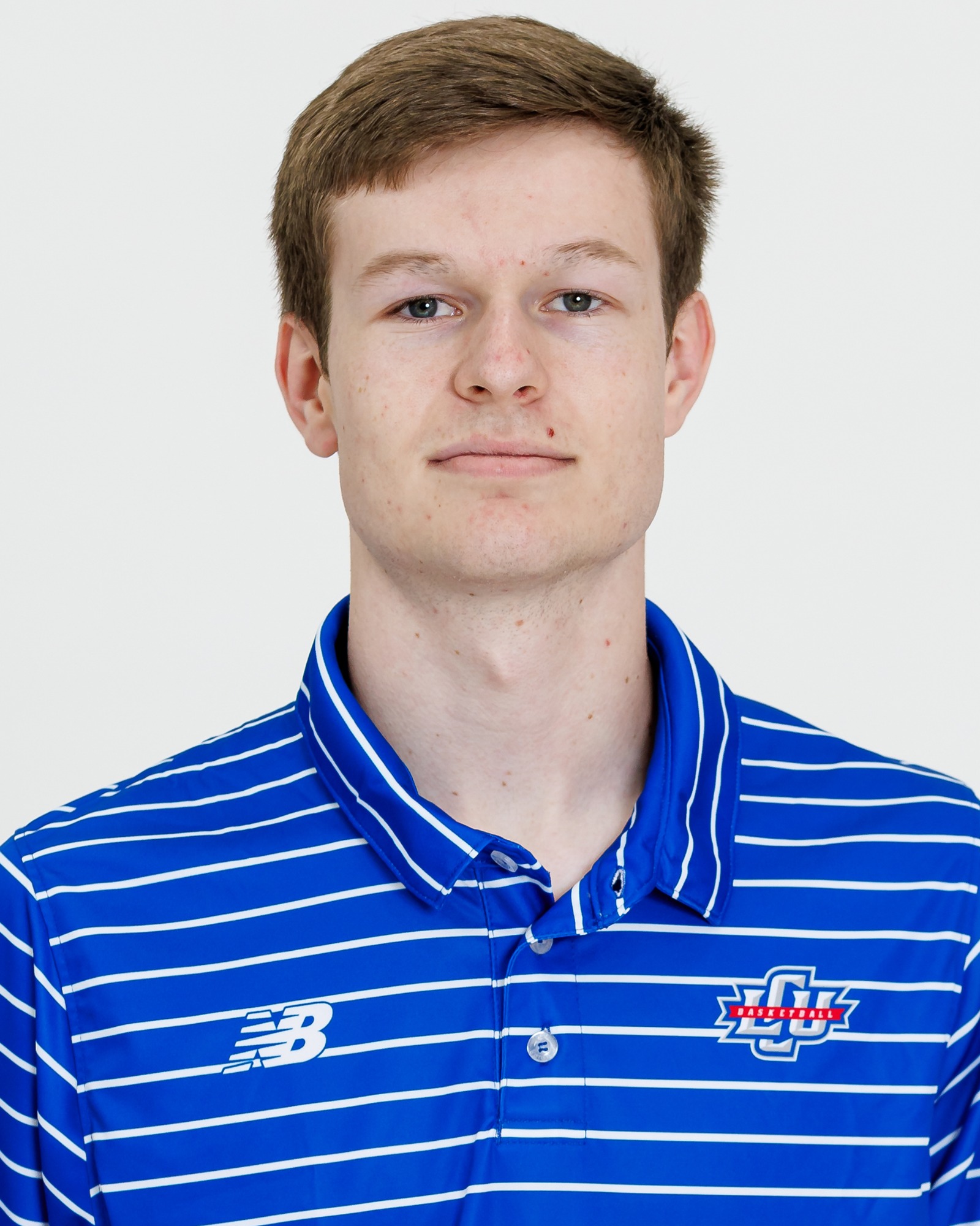 A Lubbock Christian men's basketball player wearing a blue polo with white stripes.