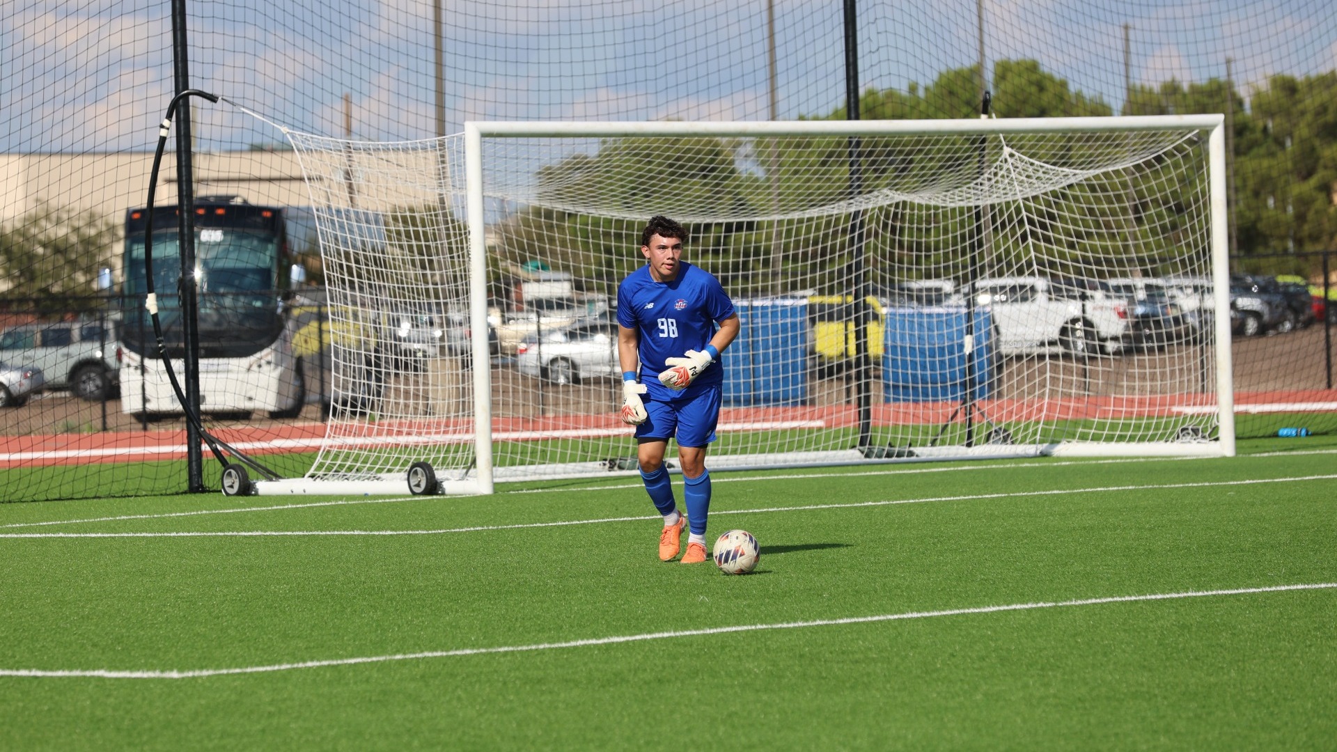 This is a photo of Lubbock Christian goalkeeper Arath Valdez (blue jersey, #98) preparing to kick the ball during a game at the LCU Soccer & Track Complex.
