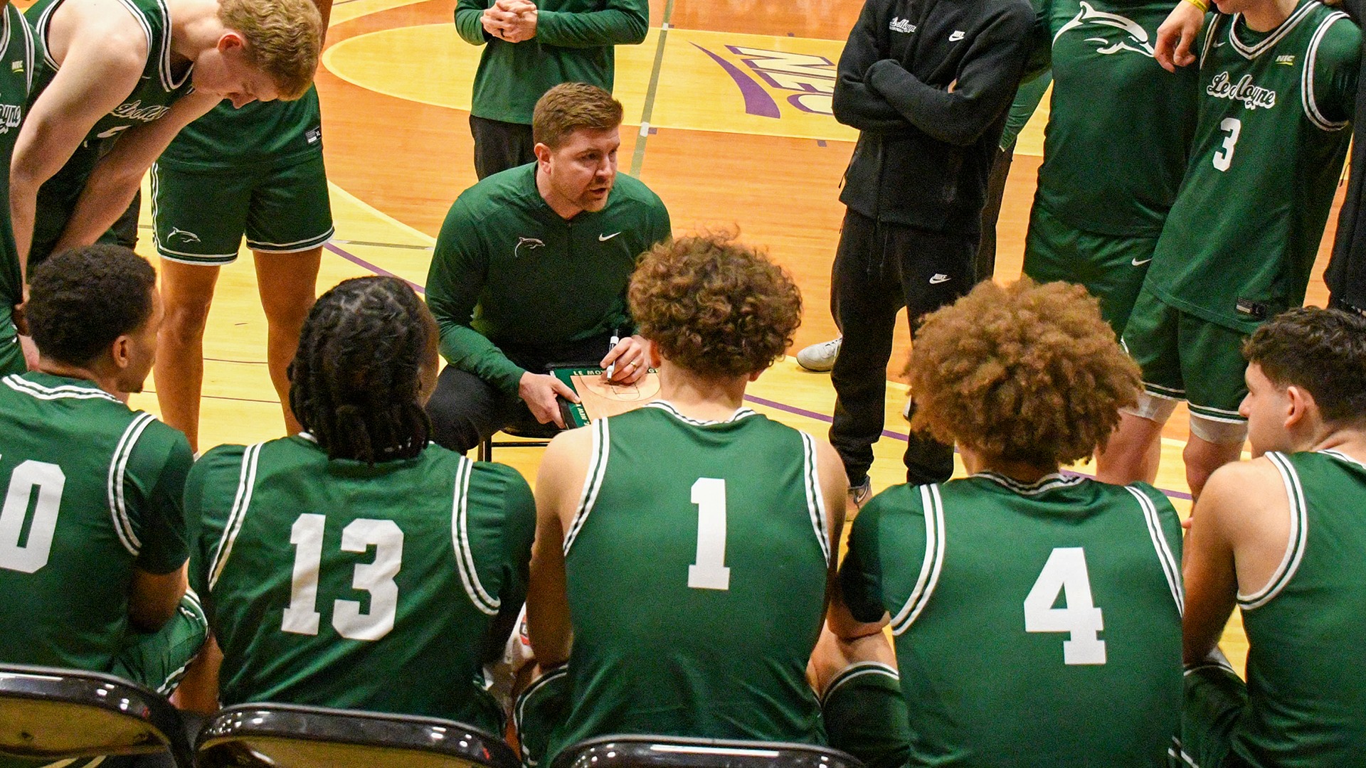 Coach Champion speaks to starters prior to Stonehill game