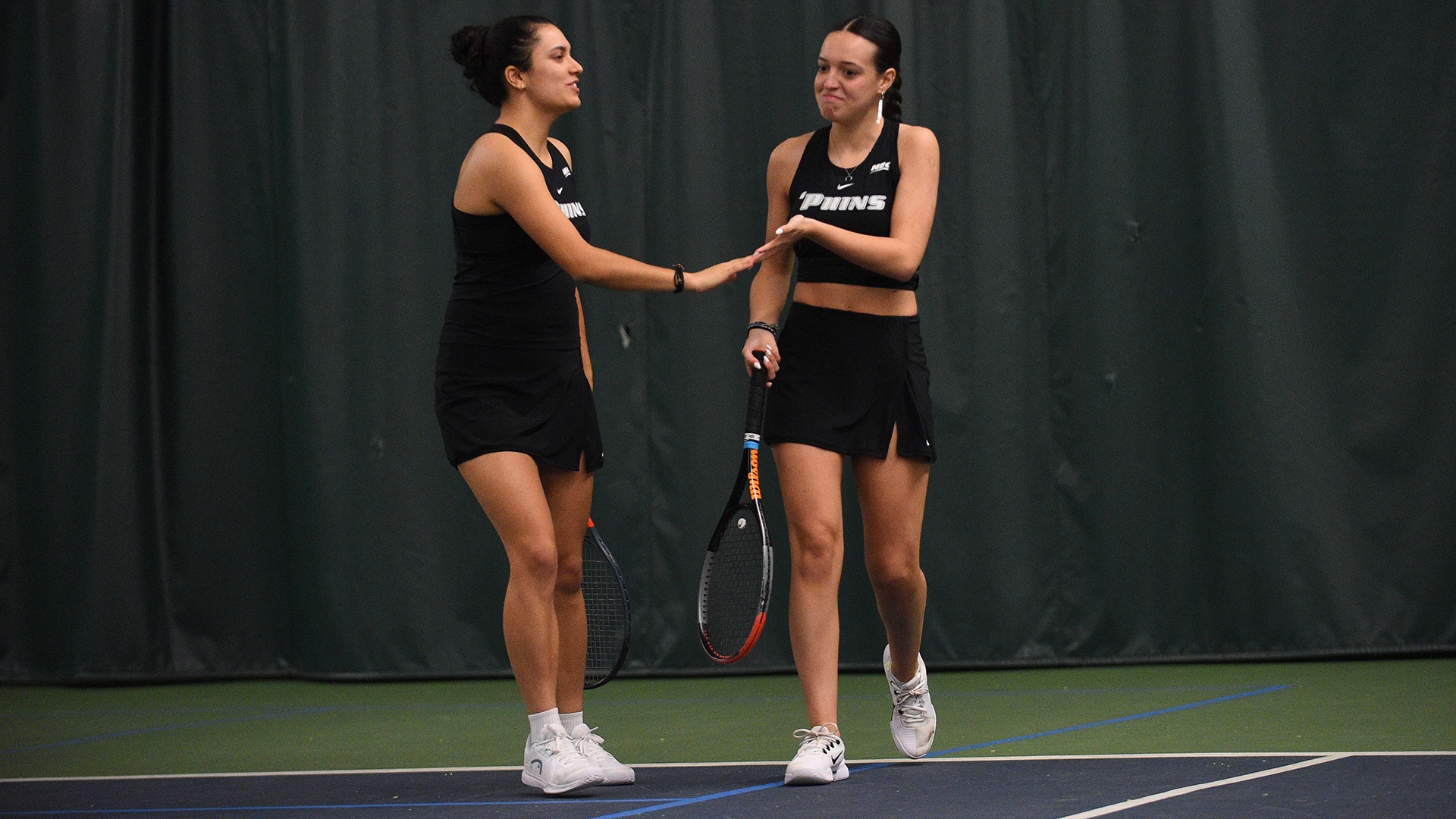 Ella Fernando and Paula Casares celebrate a point by slapping hands