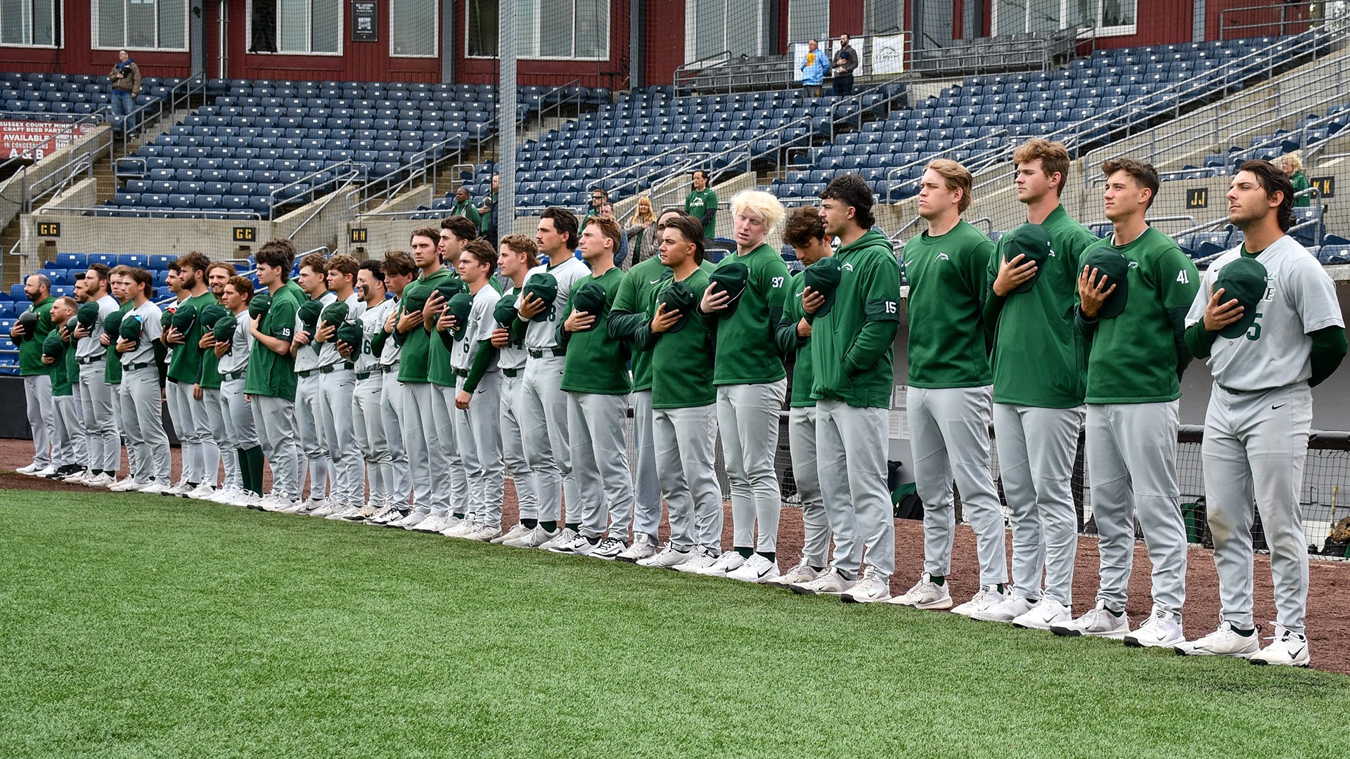 The baseball team stands for the national anthem prior to the first game of the NEC Championship