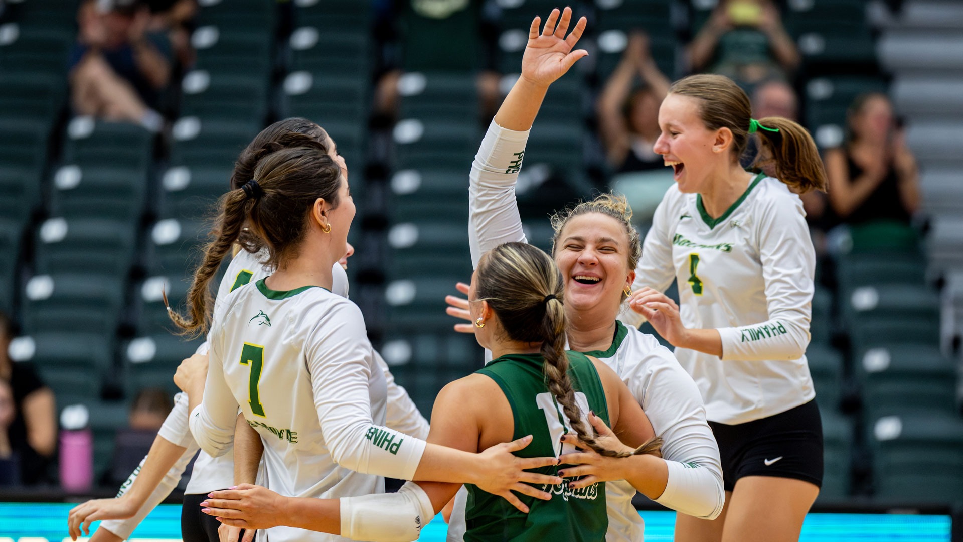 Members of the volleyball team celebrate a point during the Siena Invitational
