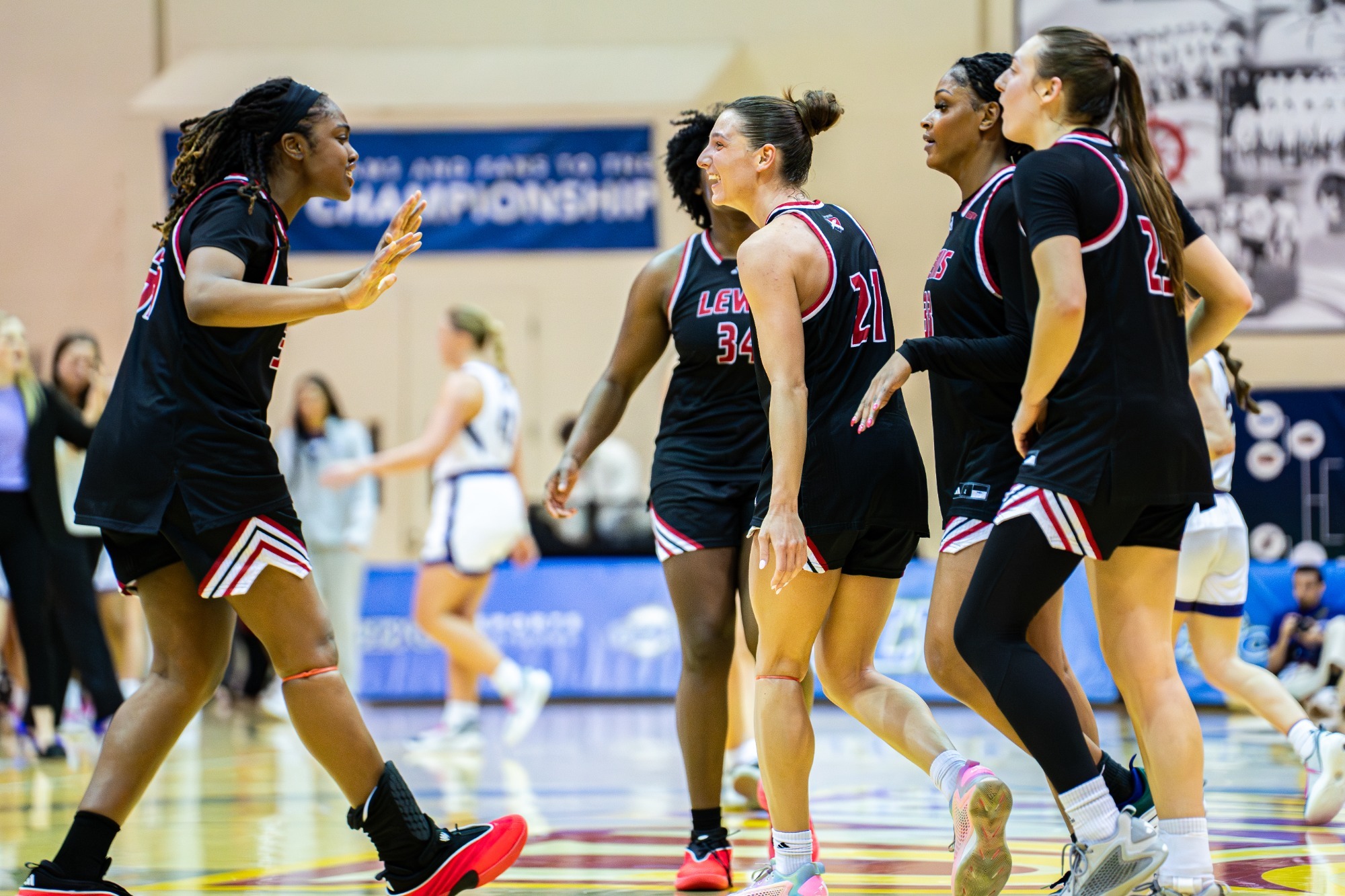 Women's basketball players huddle in the GLVC Tournament