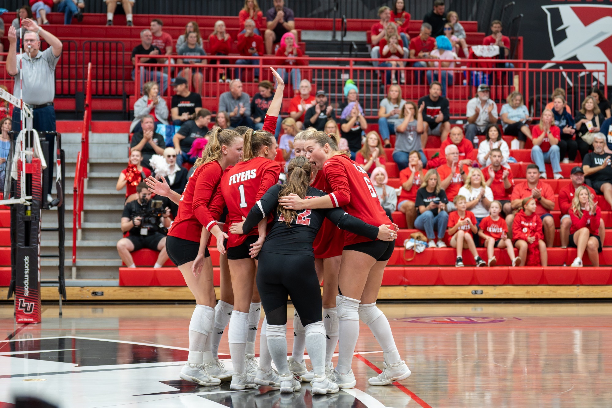 Women's volleyball huddle after a win