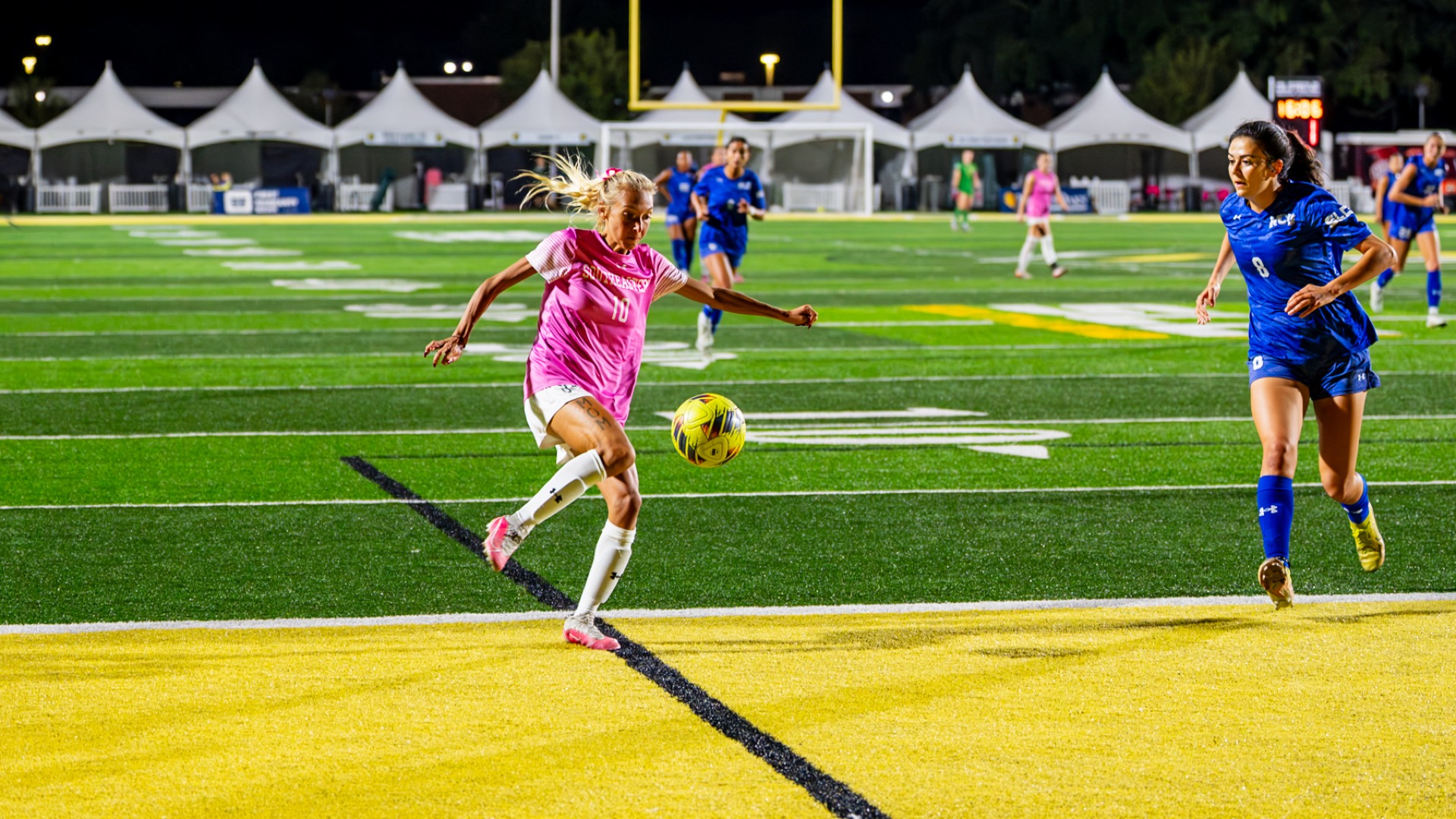 Women's soccer player Kaitlyn Tung vs HCU taking a shot around the net