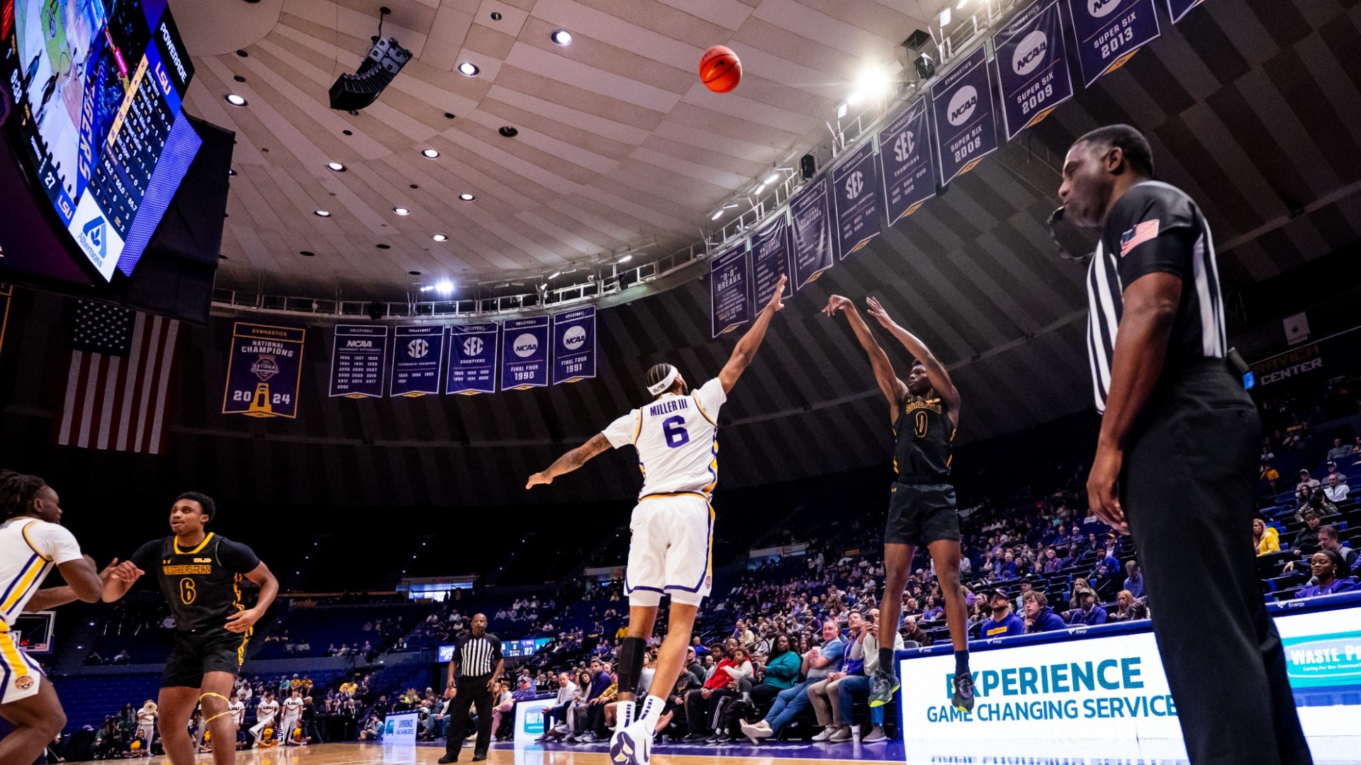 Jeremy Elyzee shooting a corner three-pointer vs LSU defender in the Pete Maravich Assembly Center