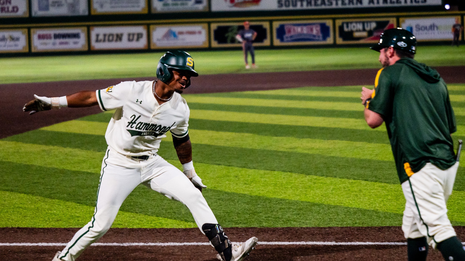 Mo Little high-fives assistant coach Taylor Dugas as he rounds third base following his home run against UTRGV.