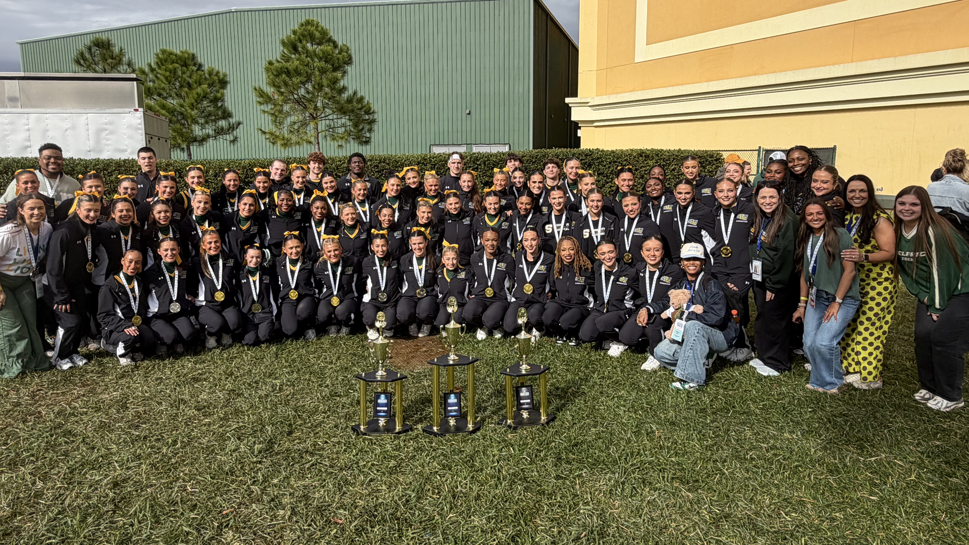 SLU cheerleading and dance squads pose combined with their 2026 trophies and gold medals from the UCA & UDA College Cheerleading and Dance Team National Championships