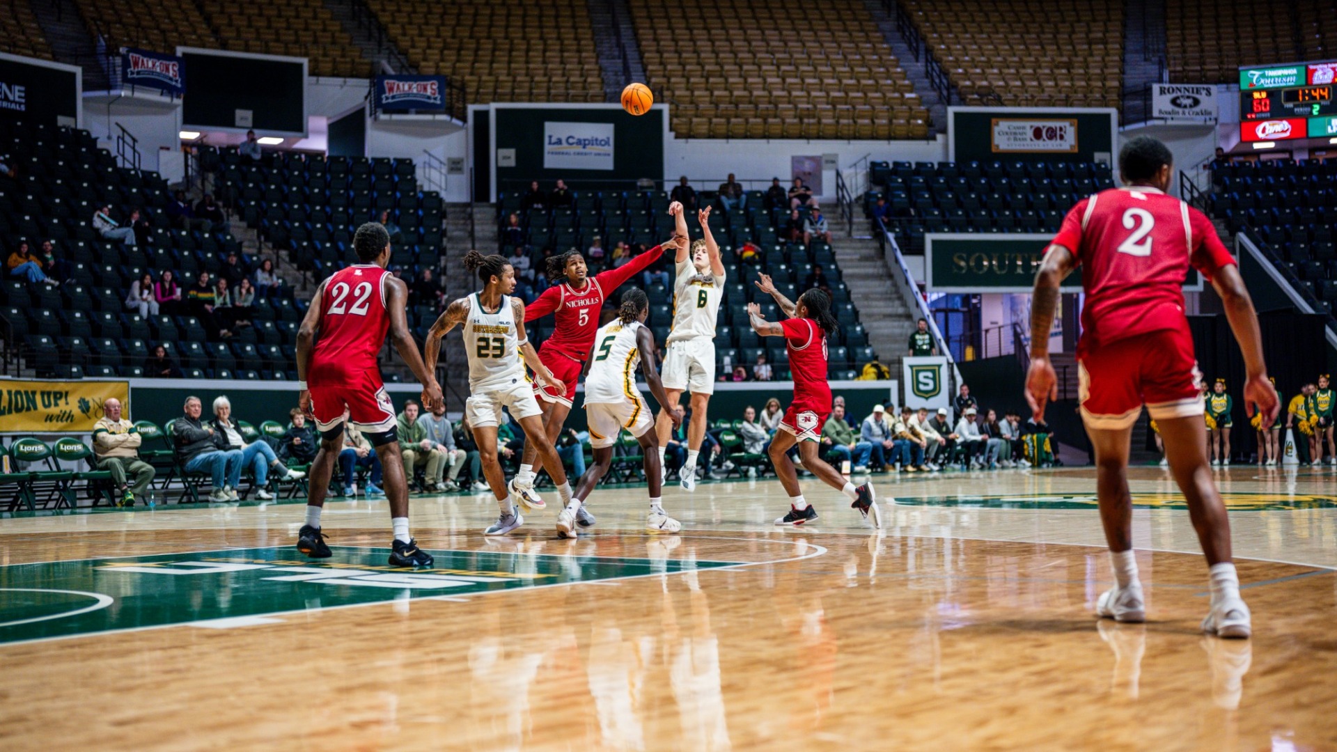 Peter Hemschemeier shooting a three-pointer over multiple Nicholls defenders