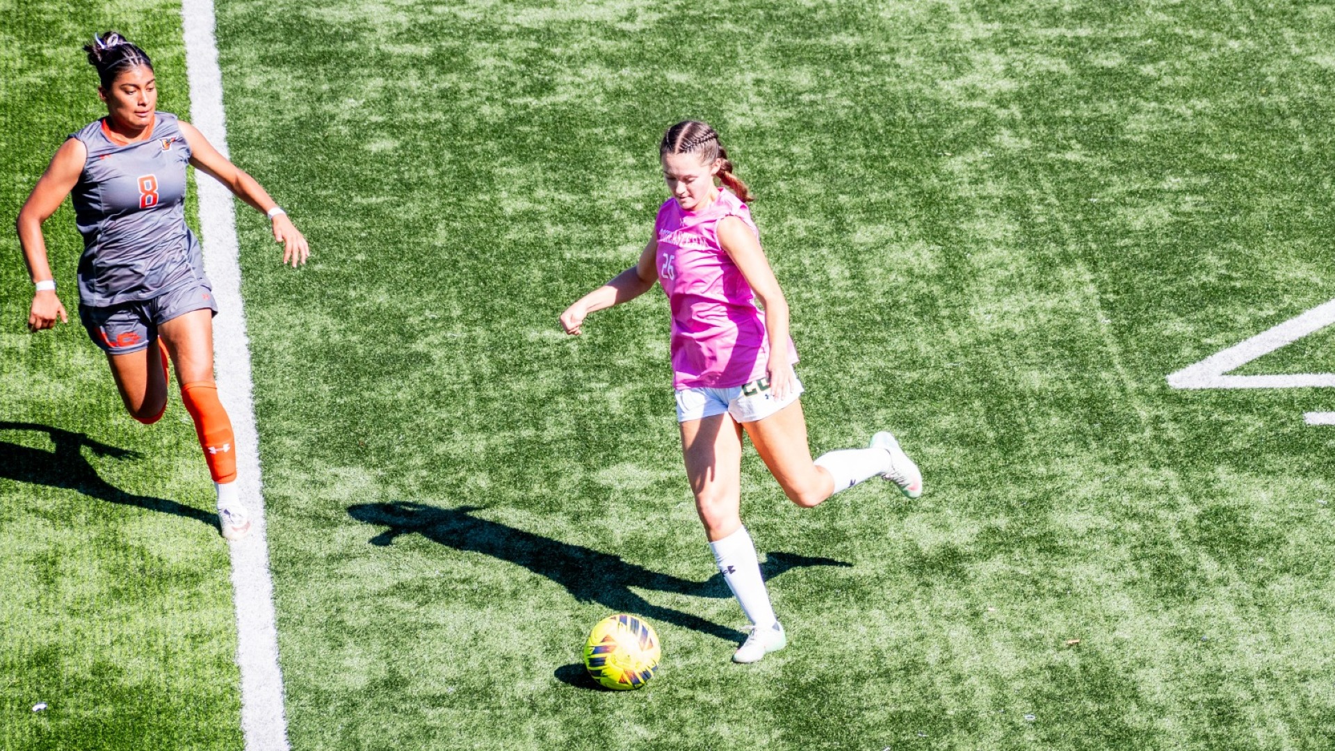 Sally Bero kicking the ball up the field vs UTRGV defender