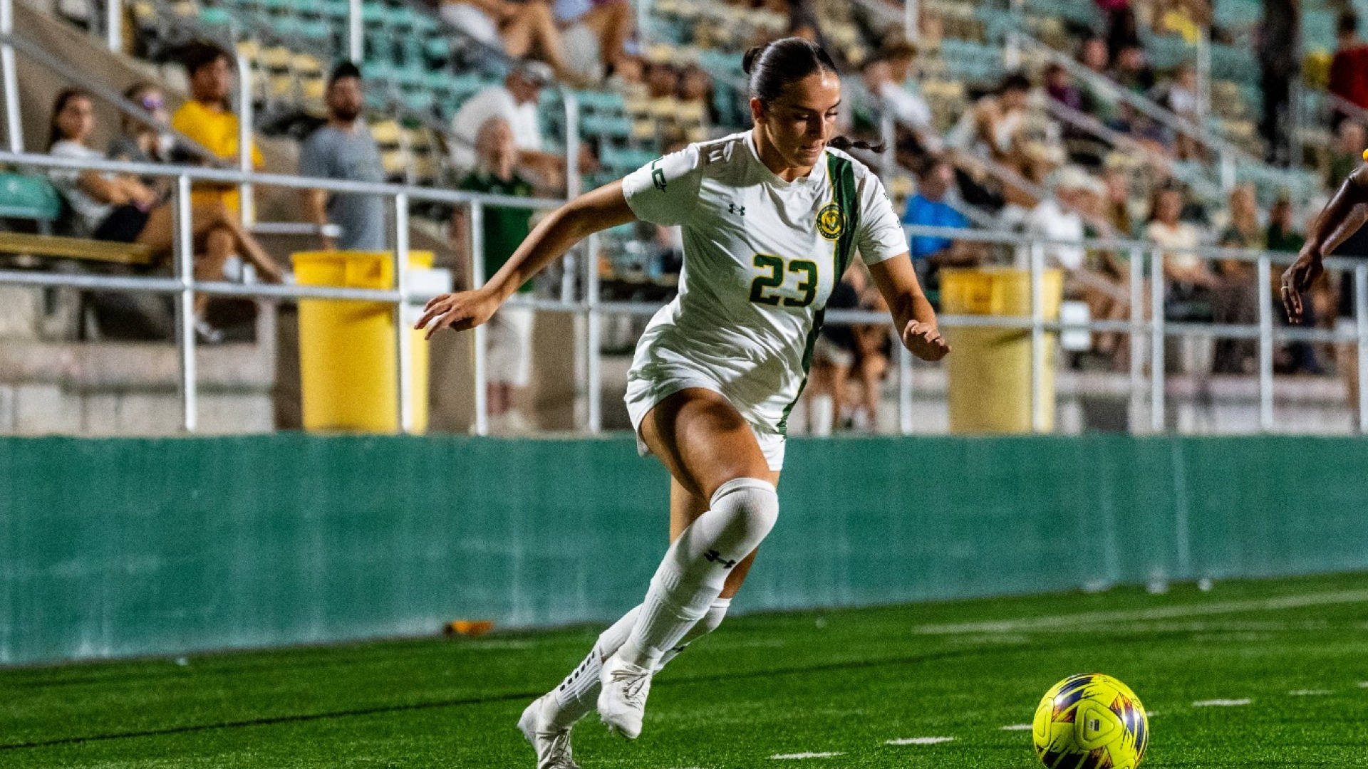 Madison Vogler (white jersey) controlling the ball up the field vs McNeese defender pictured out of the frame
